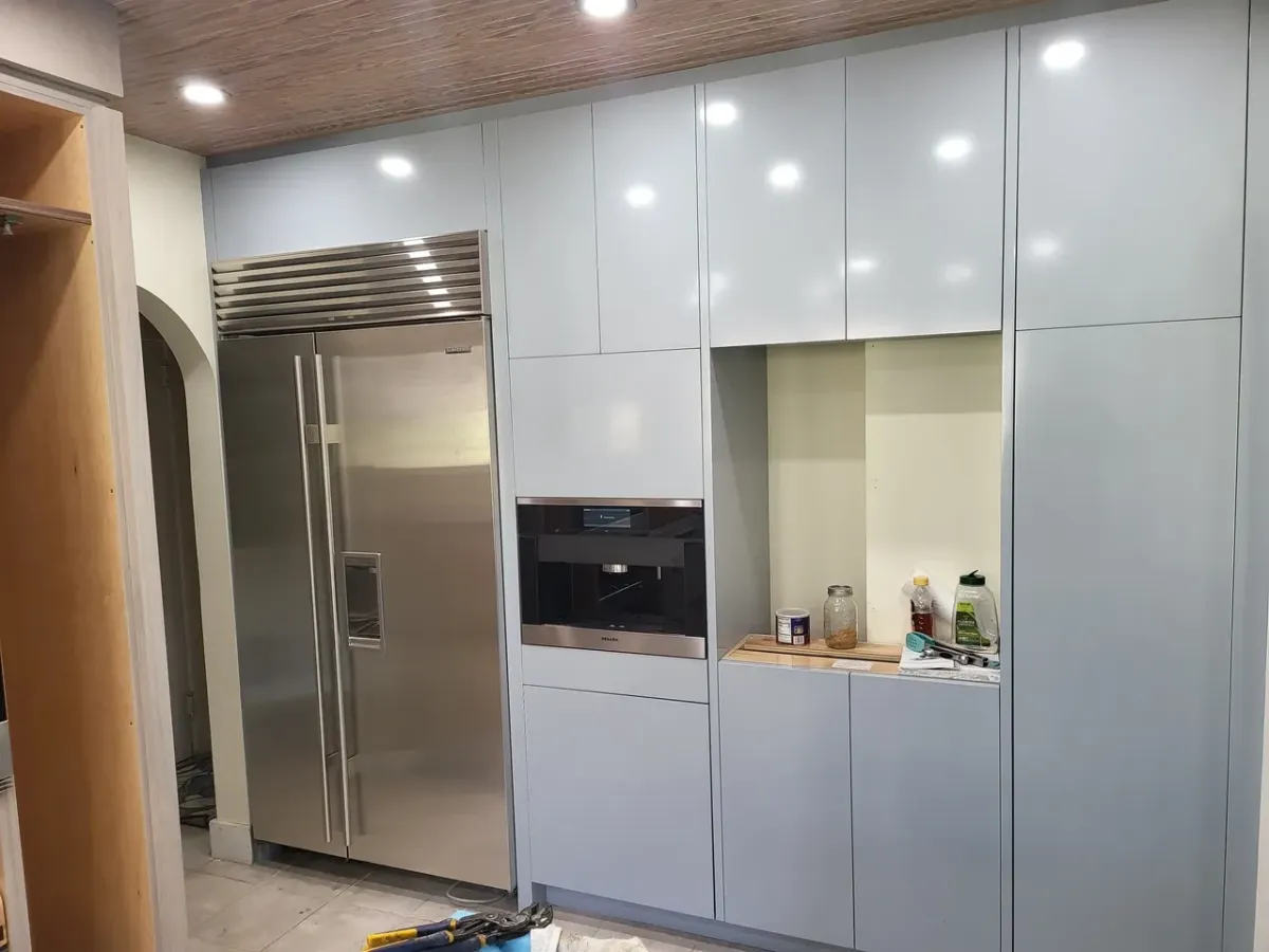 A kitchen with stainless steel appliances and white cabinets.