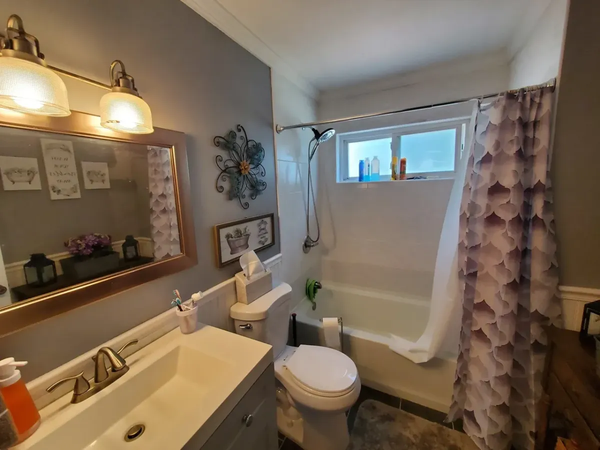 A bathroom with a toilet , sink , and bathtub.