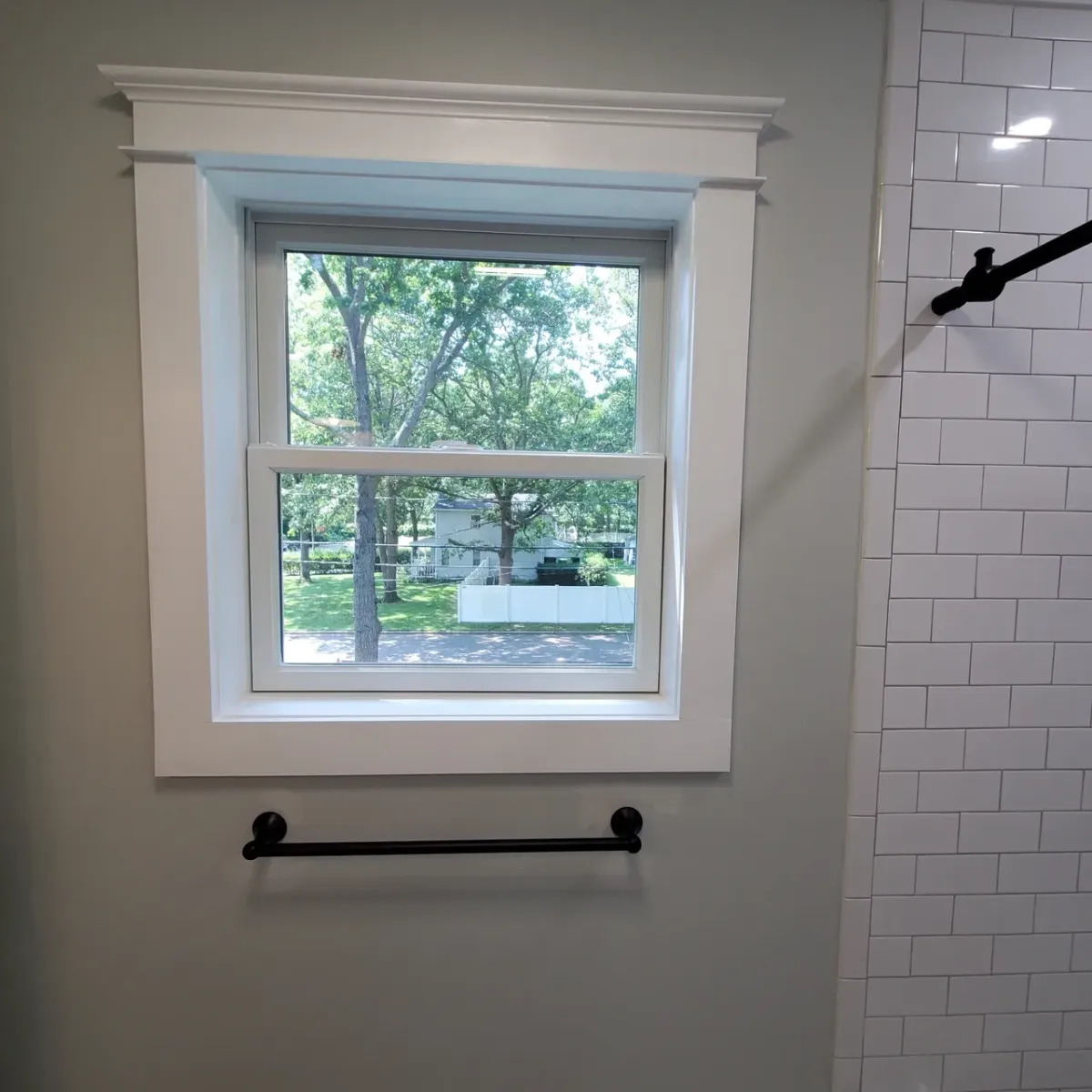 A bathroom with a window and a towel rack