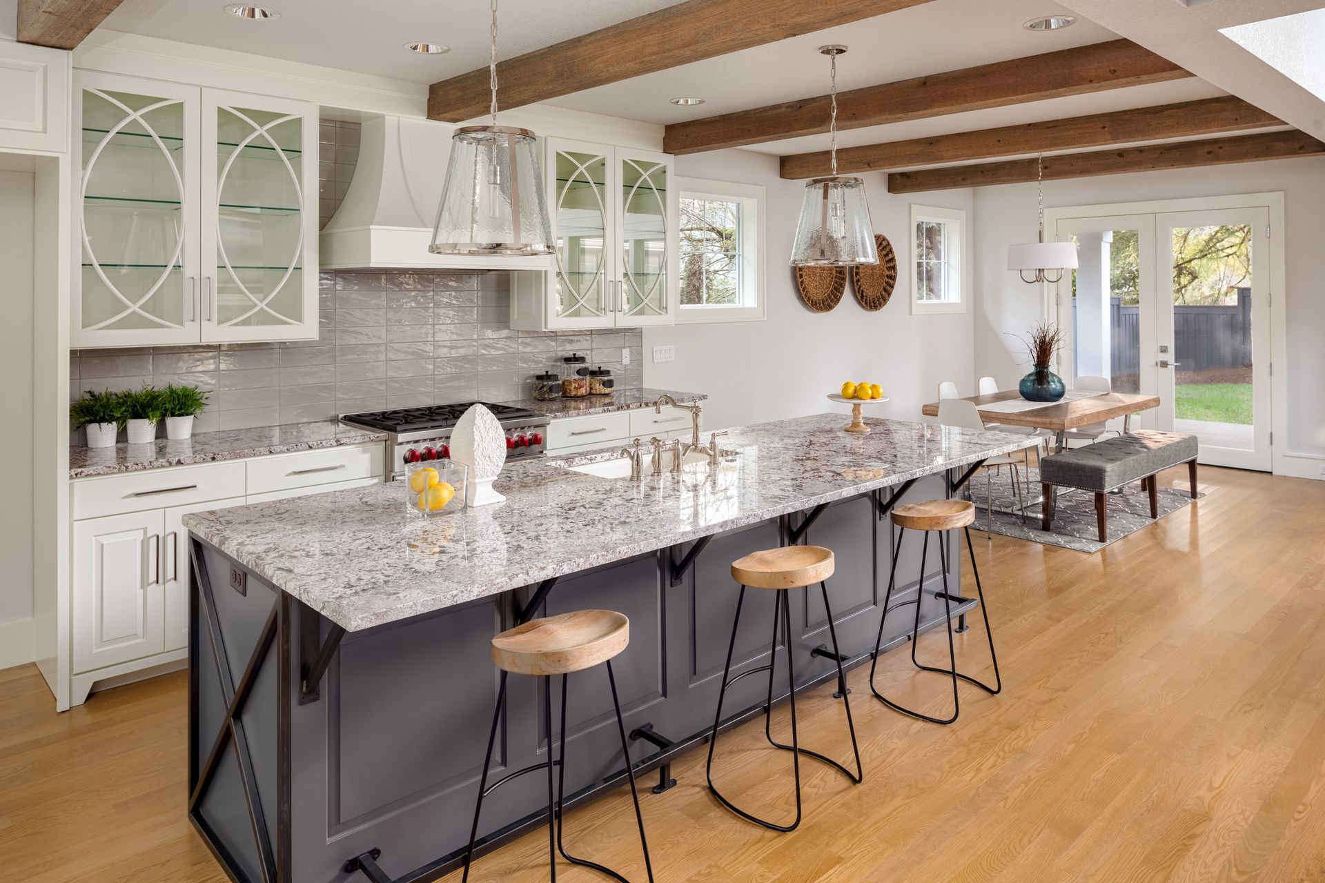A kitchen with a large island and stools in it.