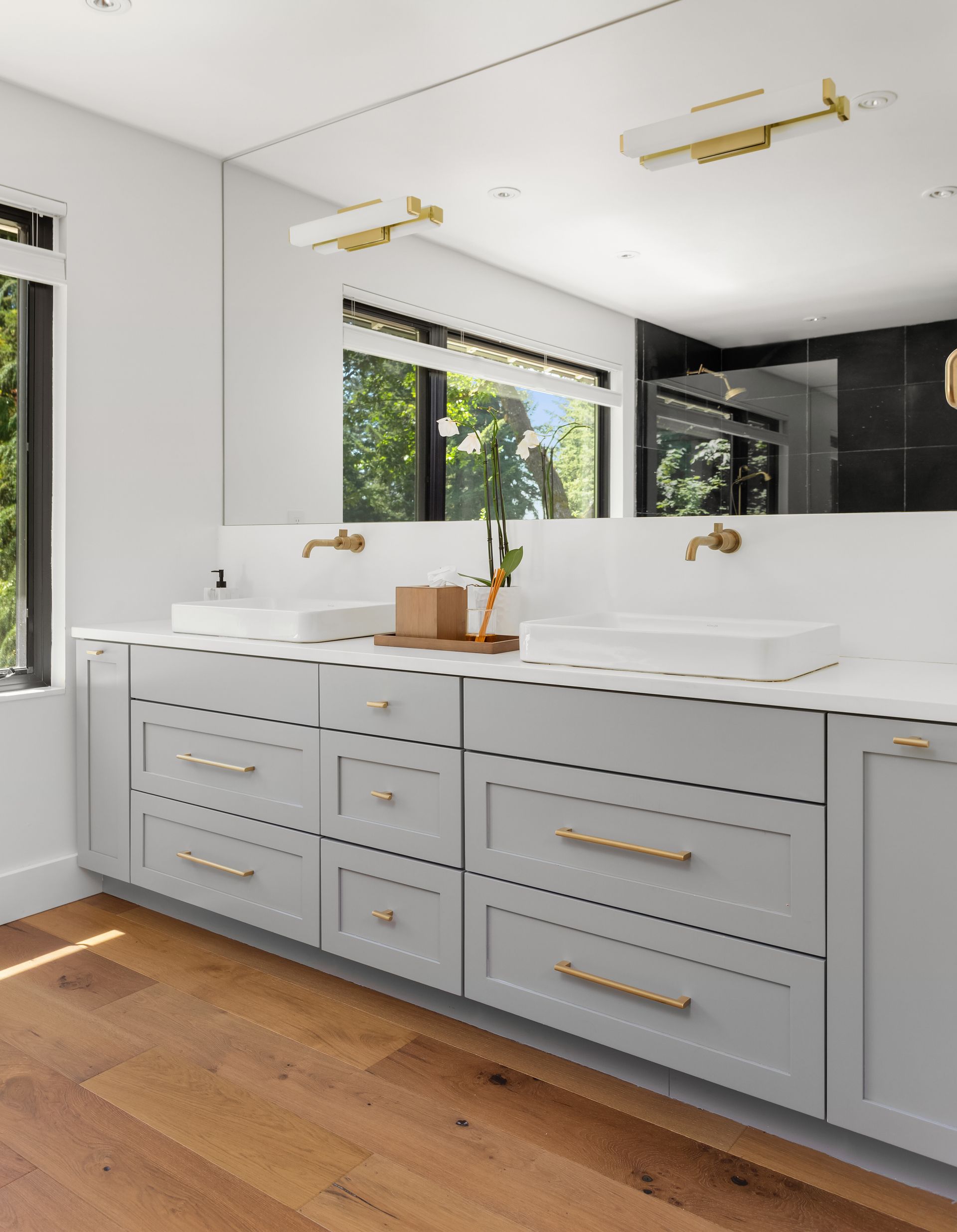 A bathroom with two sinks and a large mirror.