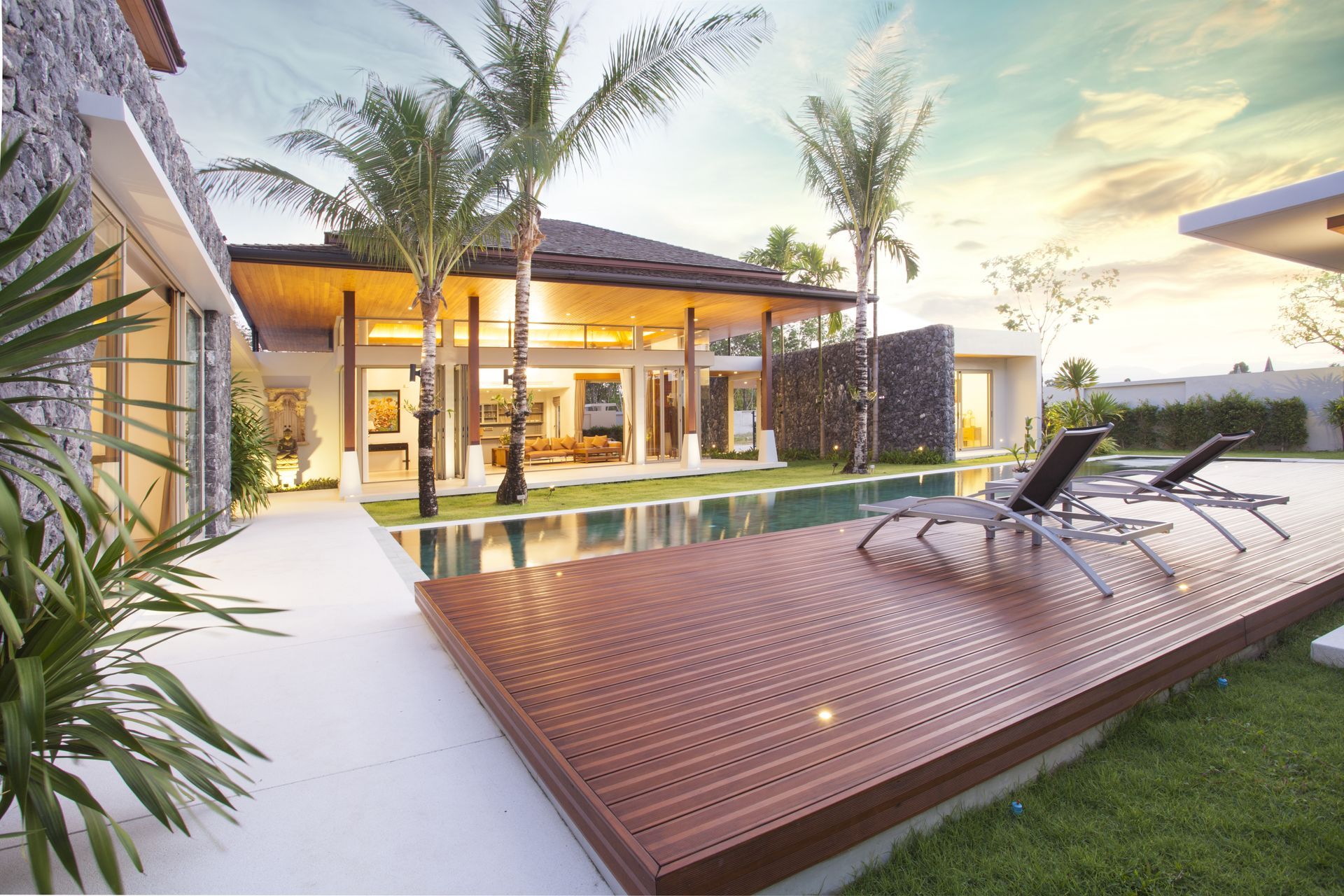 A large house with a swimming pool and a wooden deck.