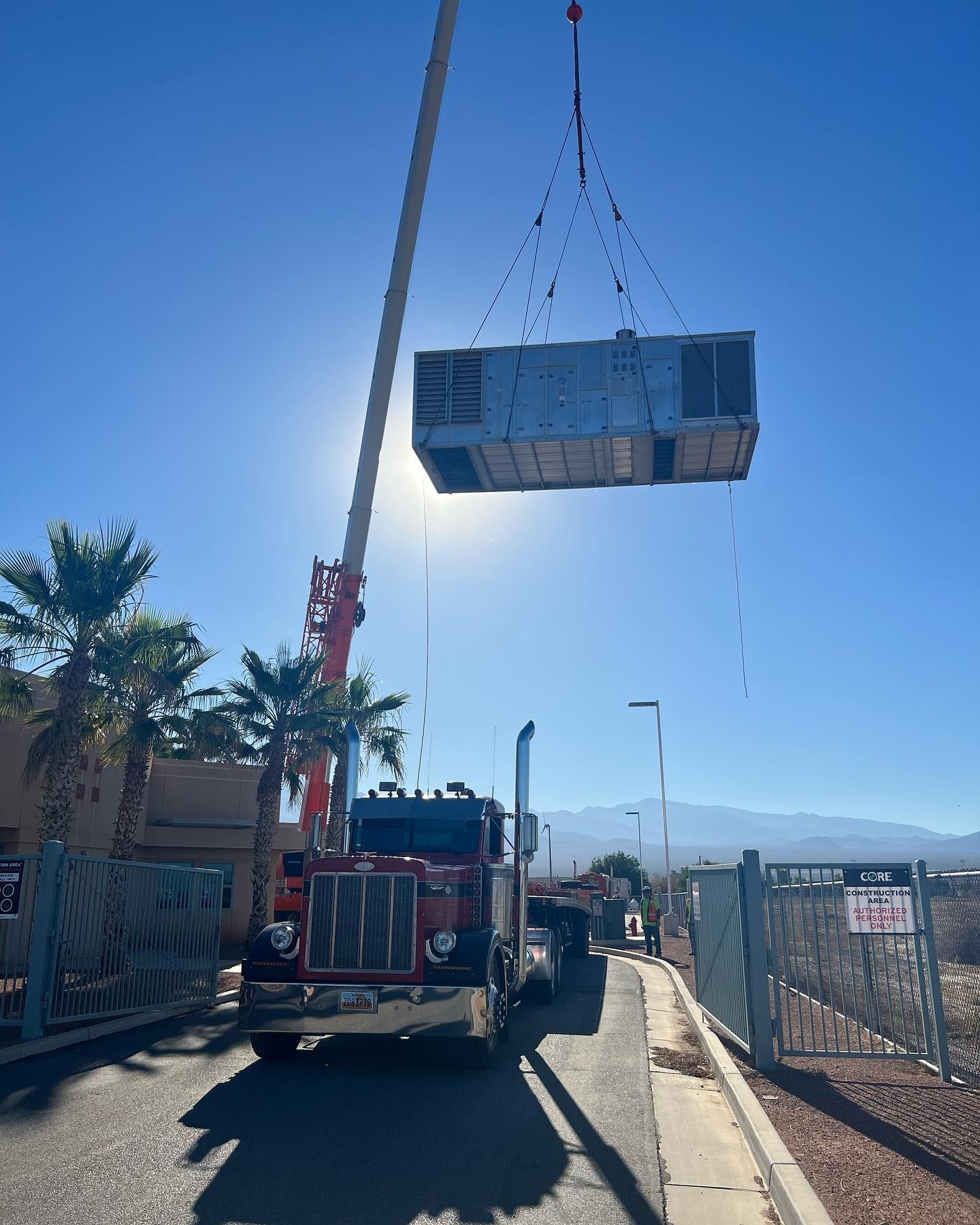 A truck is being lifted by a crane in the air