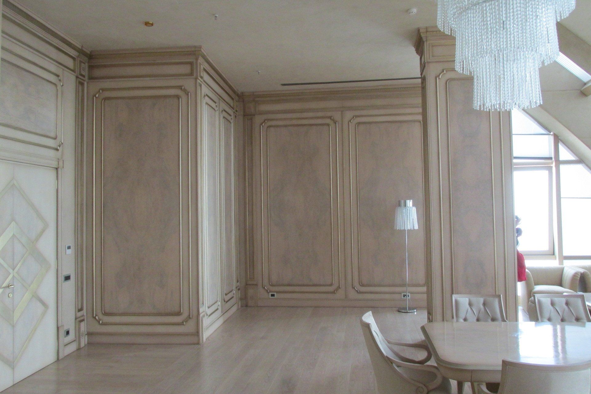 Una sala da pranzo con tavolo e sedie e un lampadario appeso al soffitto.