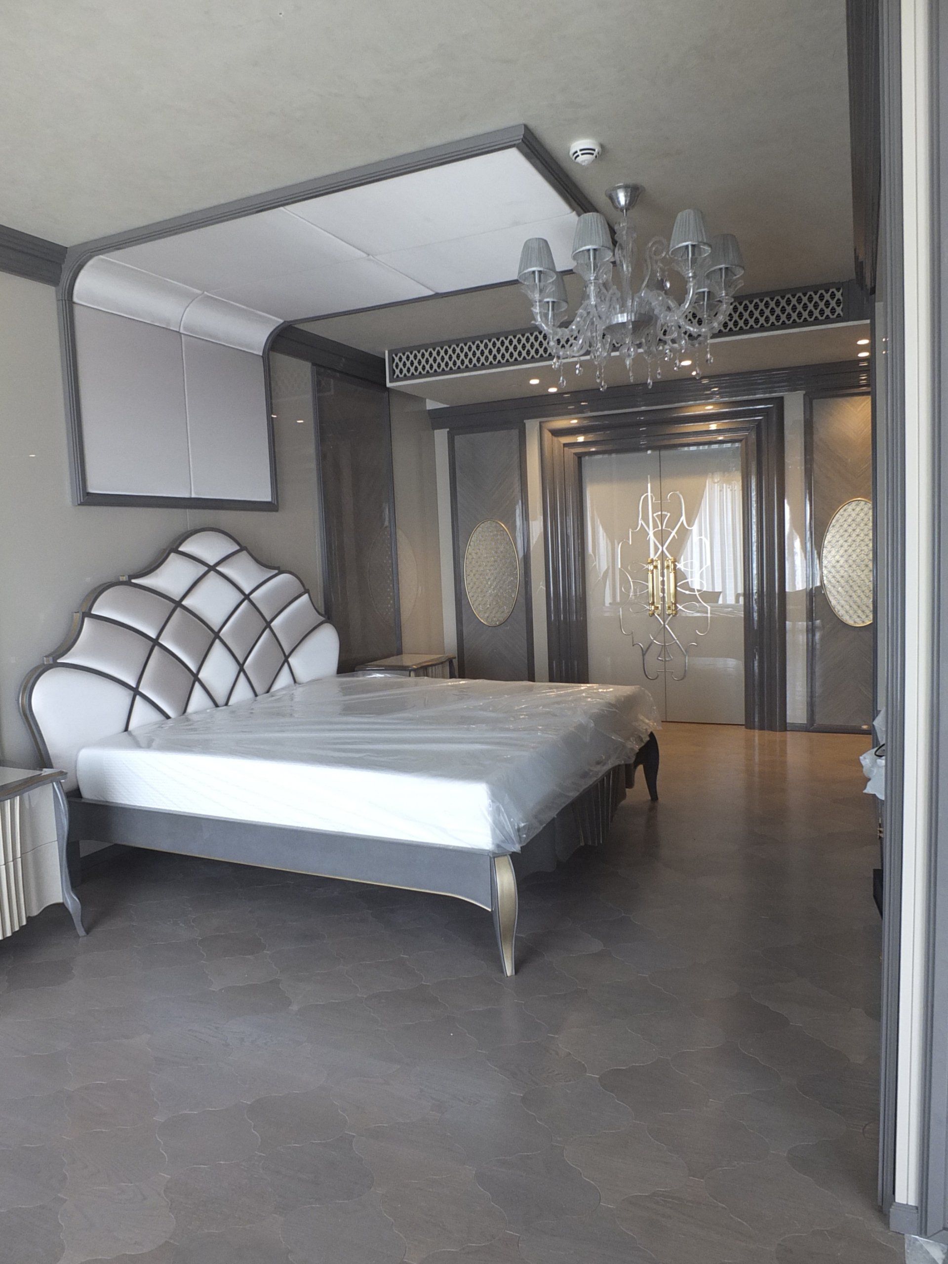 Una camera da letto con un letto matrimoniale e un lampadario appeso al soffitto.