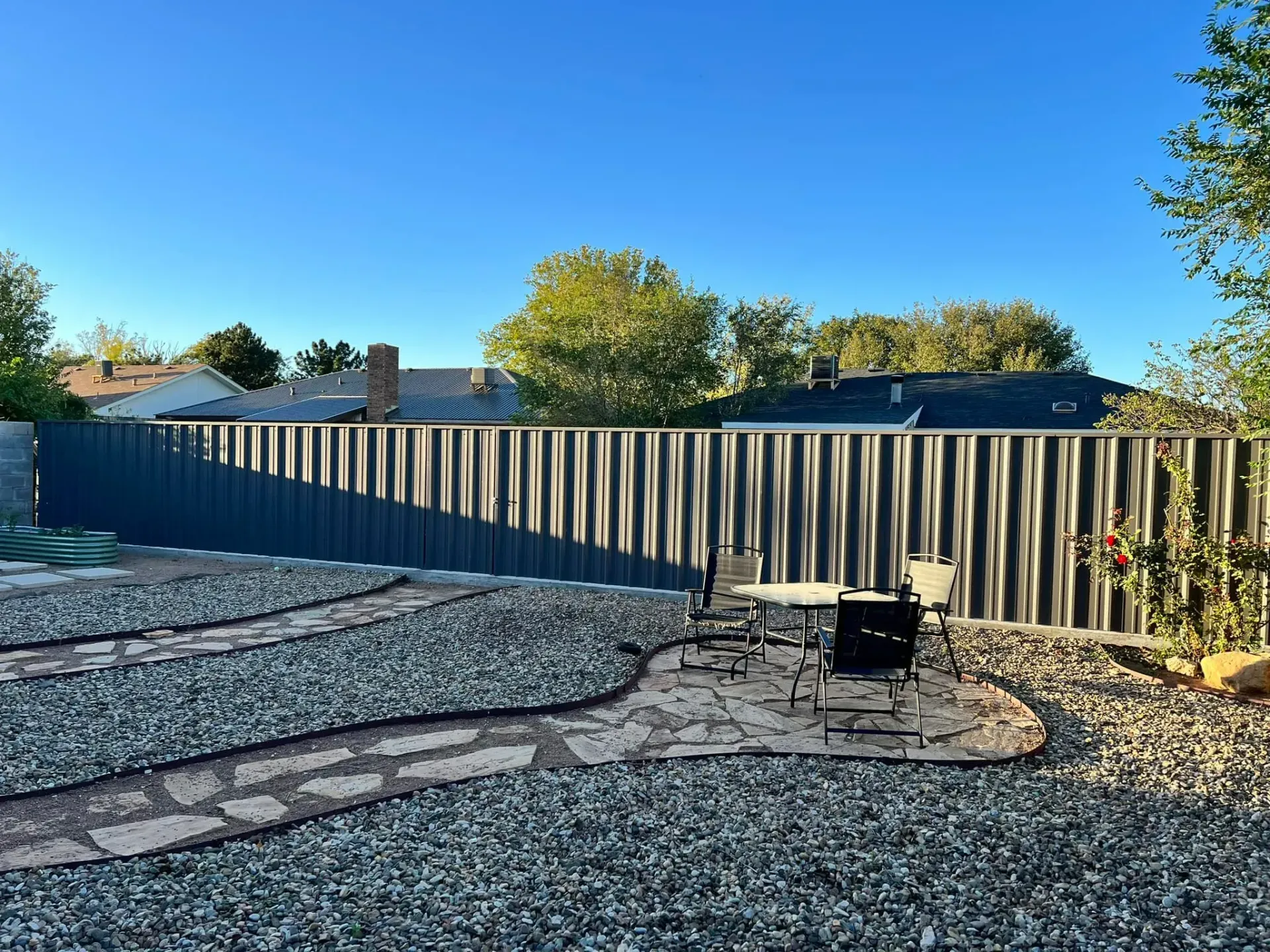A backyard with a fence and a table and chairs