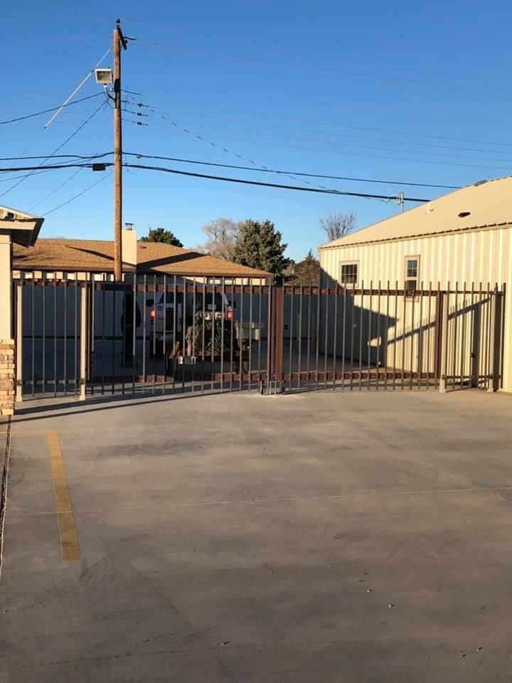 A car is parked in a parking lot behind a gate.
