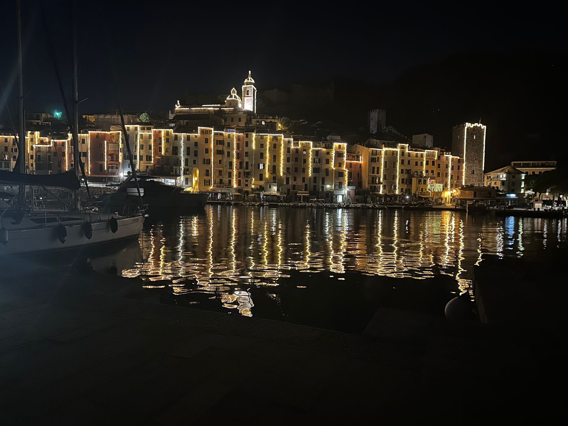 Edifici con luci calde che si riflettono nell'acqua scura di notte.