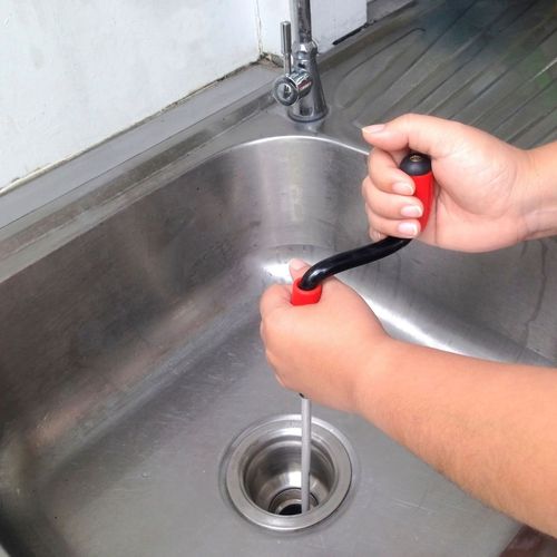 Spring Creek Water  Plumbing Services - A person is using a snake to drain a sink