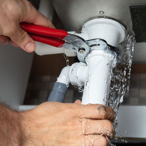 Spring Creek Water  Plumbing Services - A person is fixing a sink with a pair of pliers