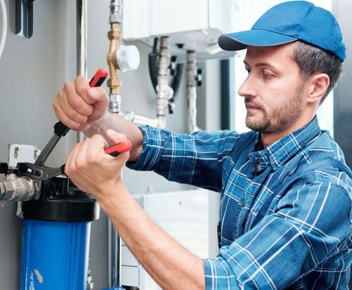 Spring Creek Water  Plumbing Services - A man is working on a pipe with a pair of pliers.
