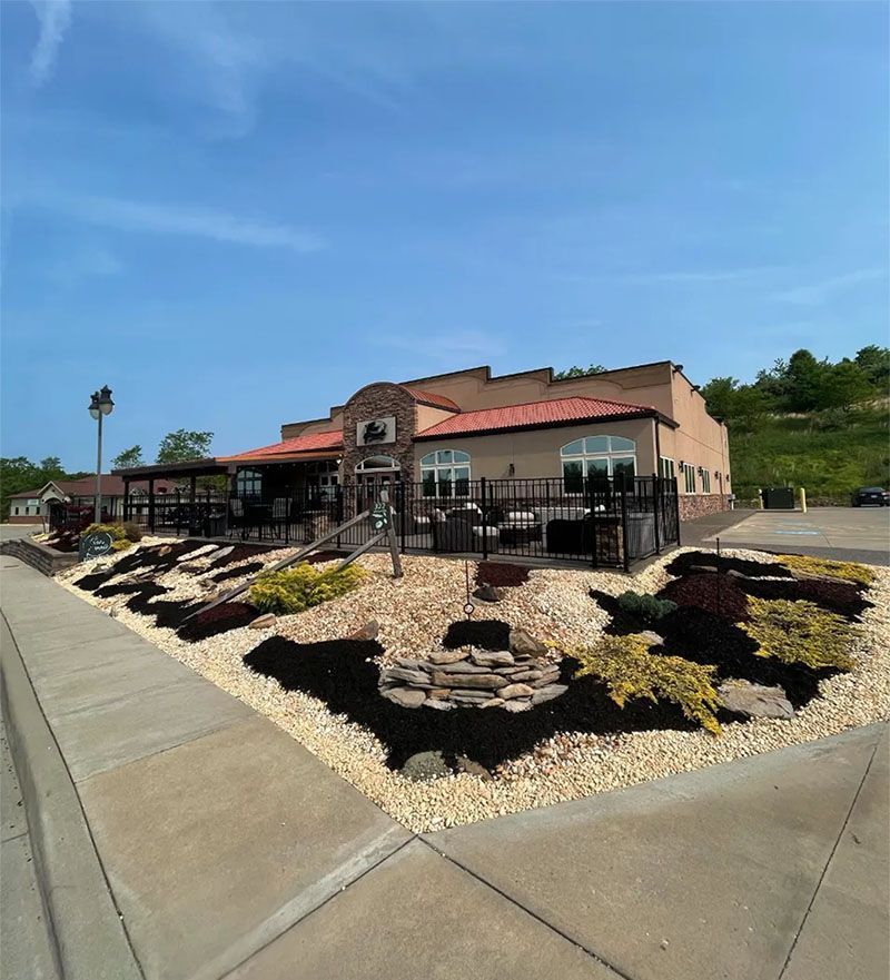 A large building with a lot of plants in front of it.