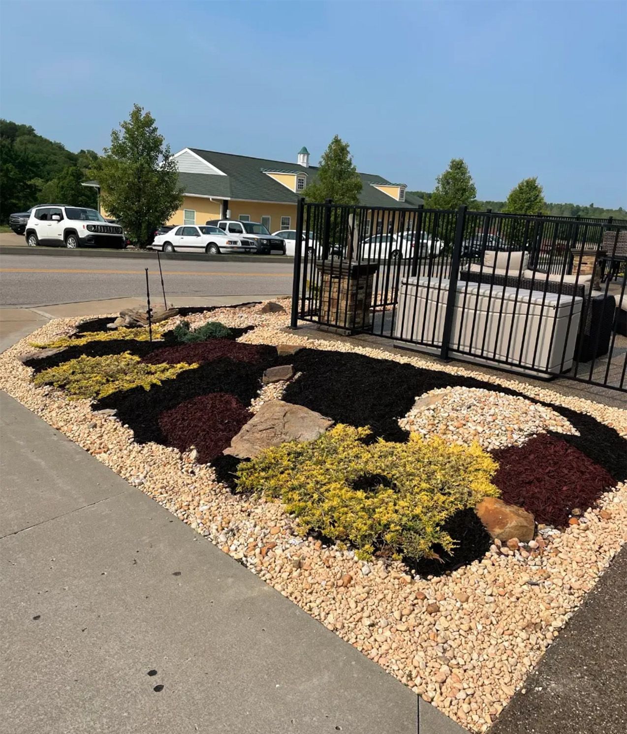 A parking lot with a fence and a garden in the shape of an eagle