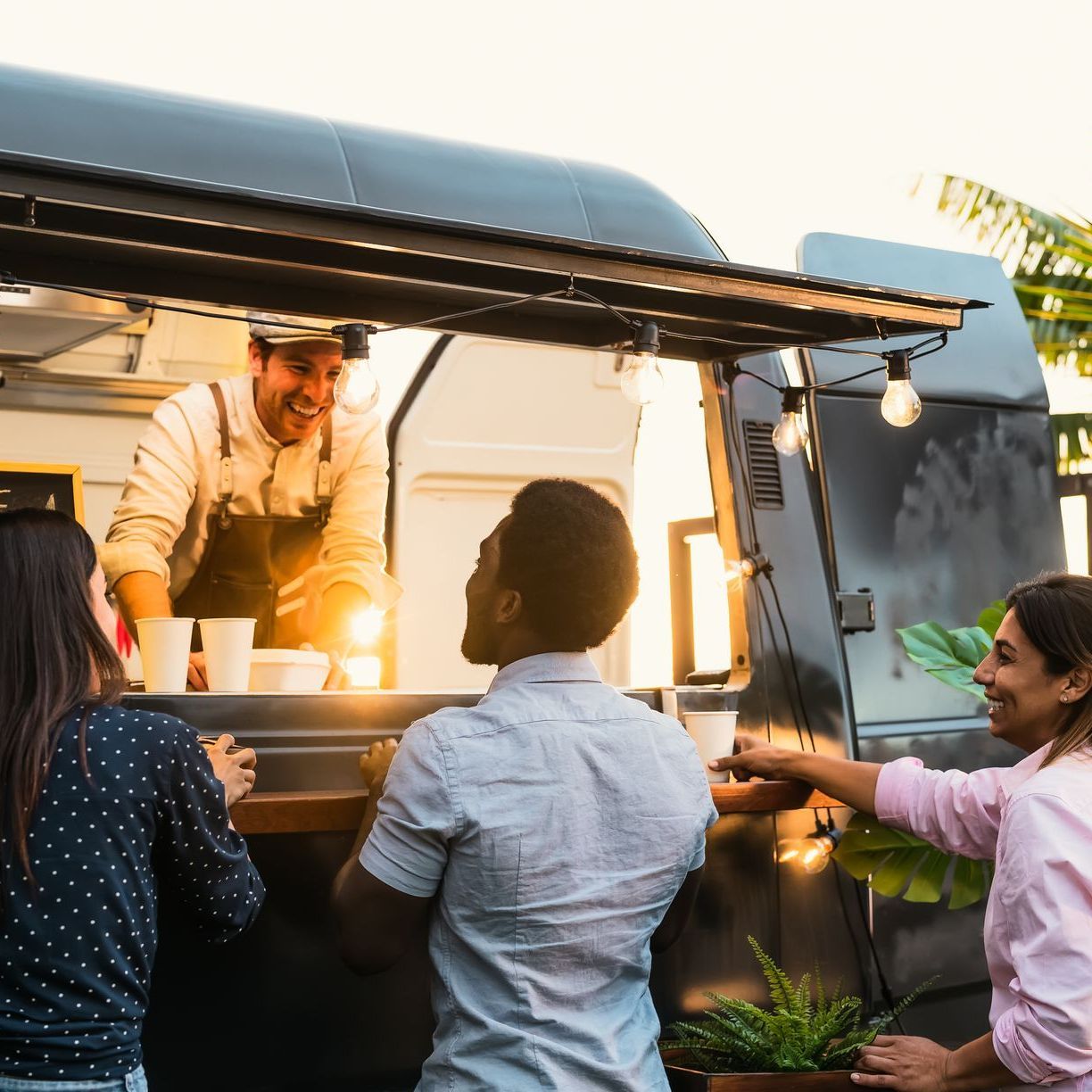 A group of people are standing in front of a food truck.