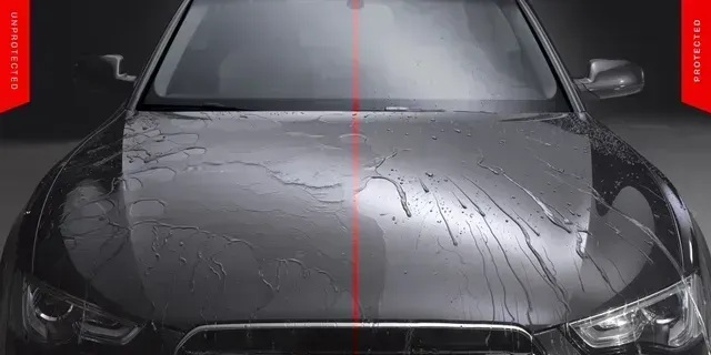 Front view of a wet black car in a dark studio, with a red centerline and water droplets on the hood