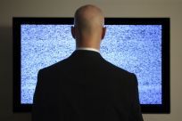 man standing in front of television static