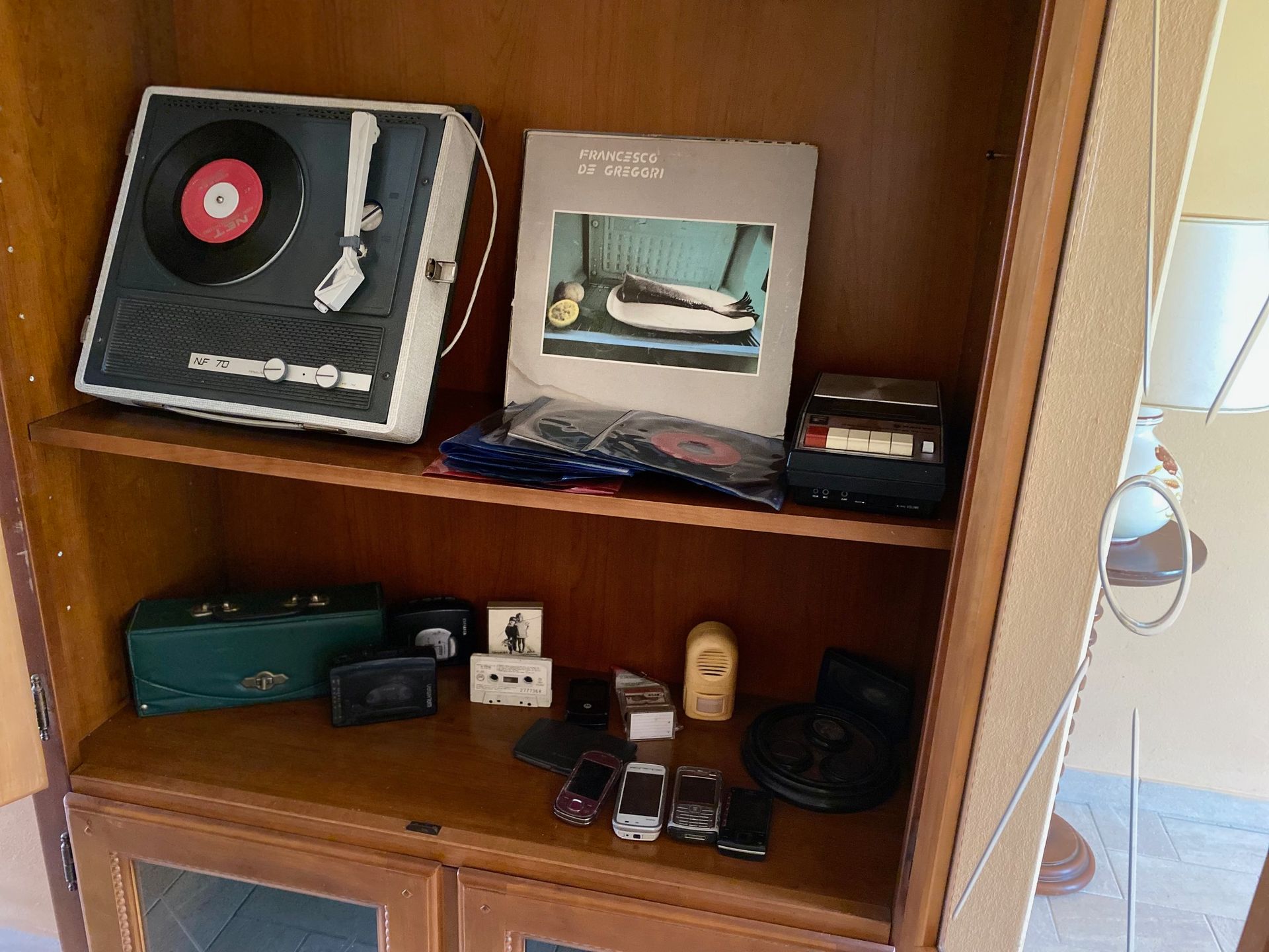 A shelf with a record player and a picture frame on top.