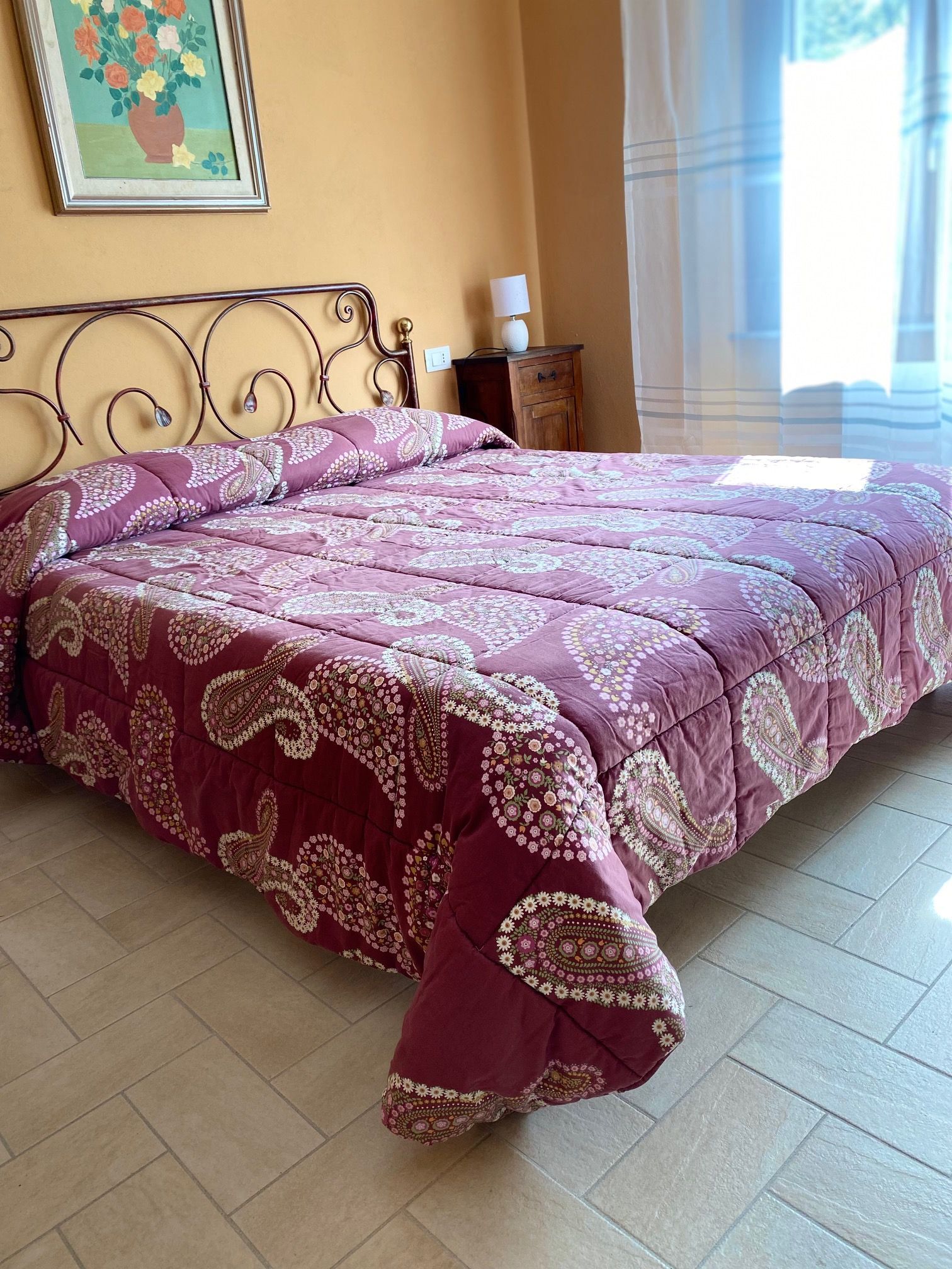 A bed with a purple quilt in a bedroom.