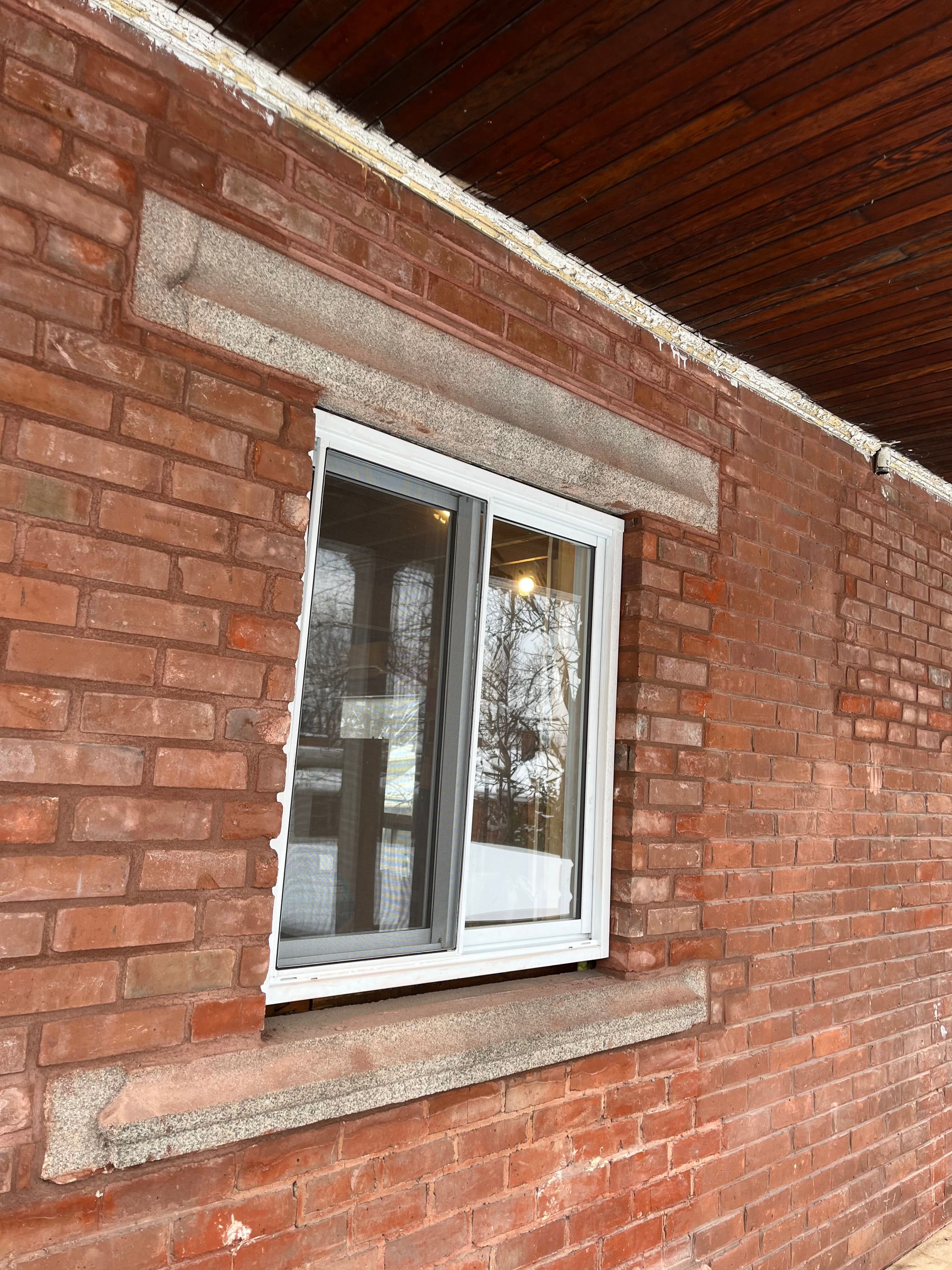 Il y a une fenêtre sur le côté d'un bâtiment en brique.