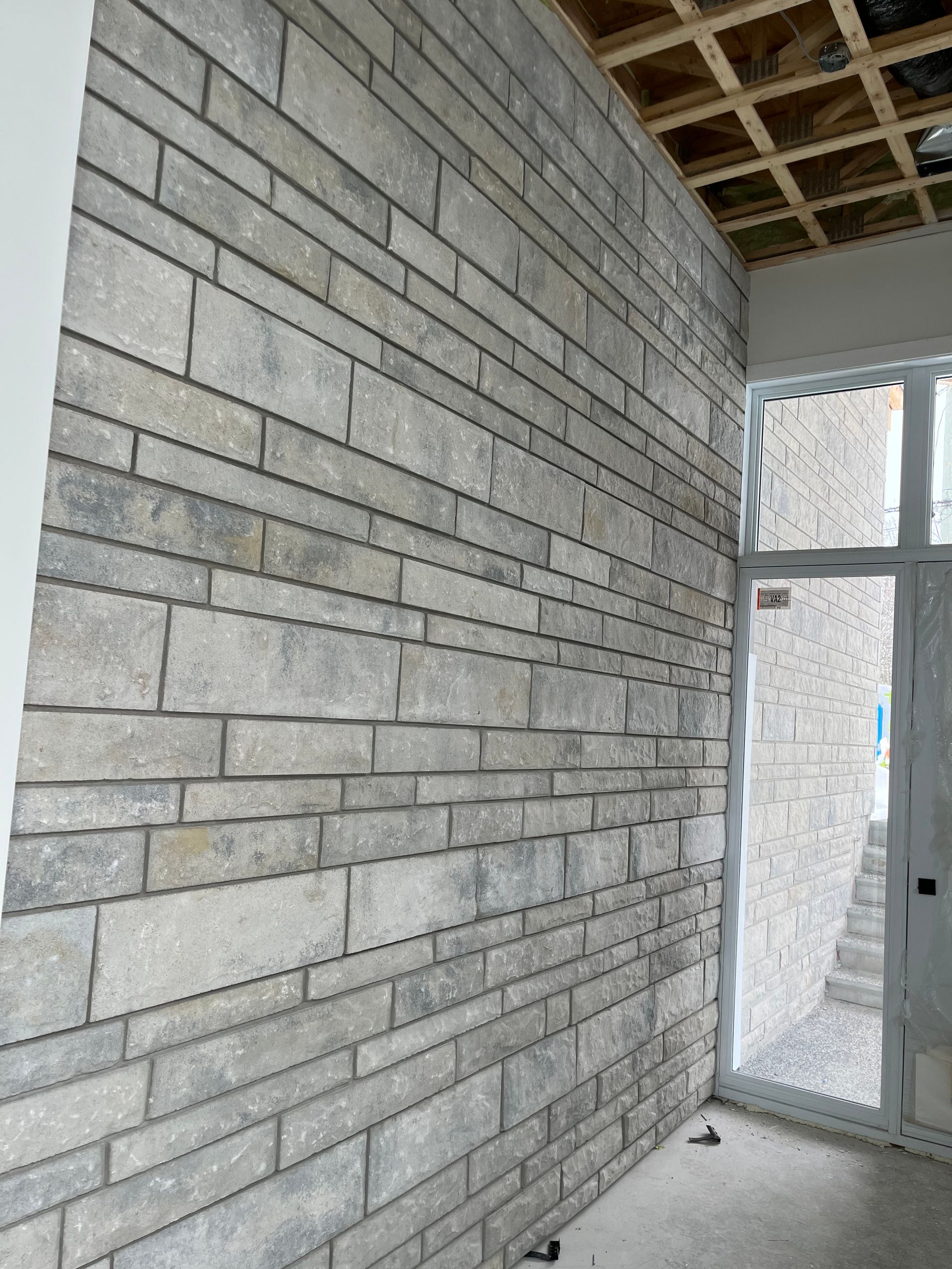 Une pièce avec un mur de briques et une porte.