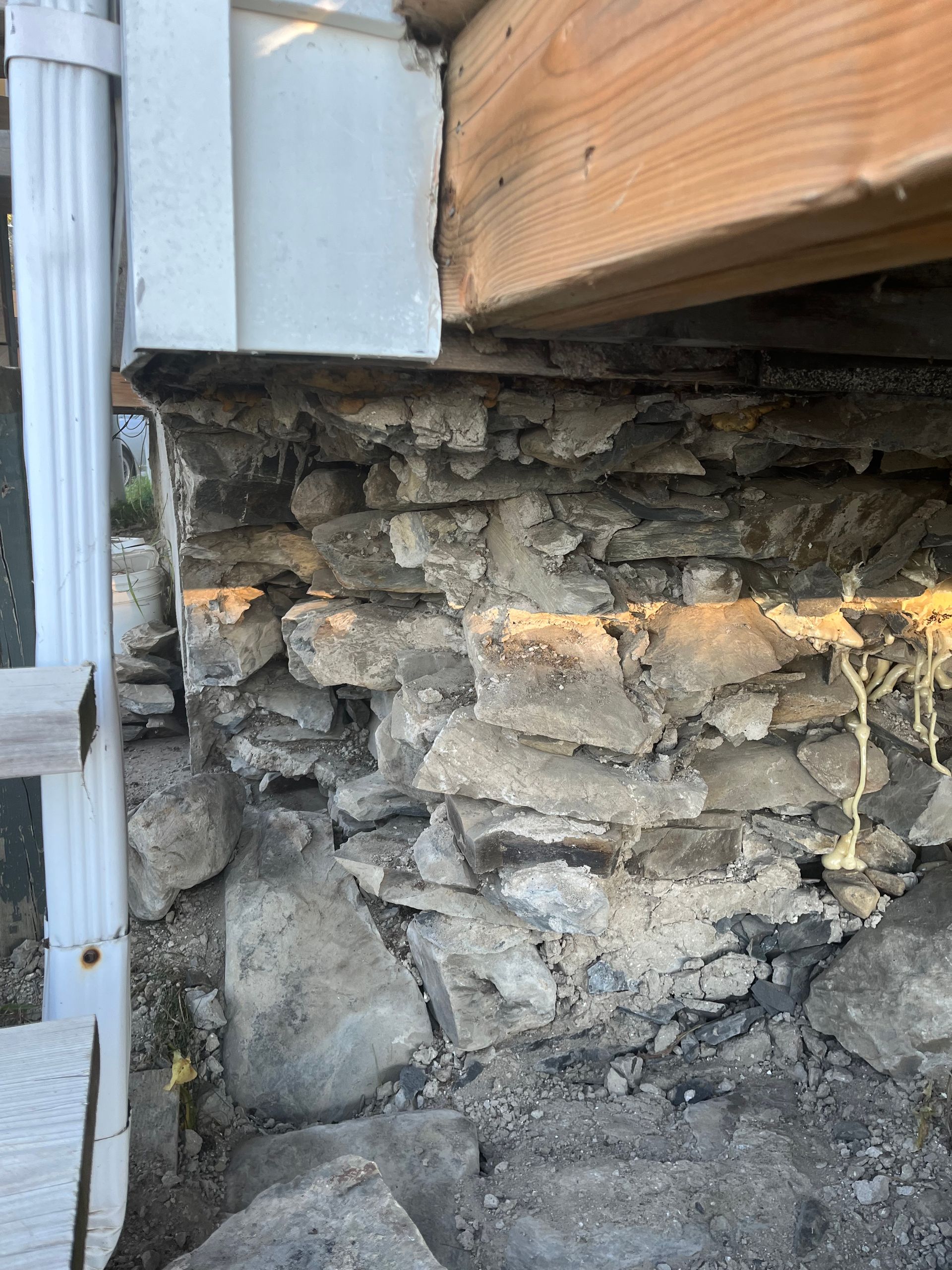 Un gros plan d'un mur de pierre sous une maison