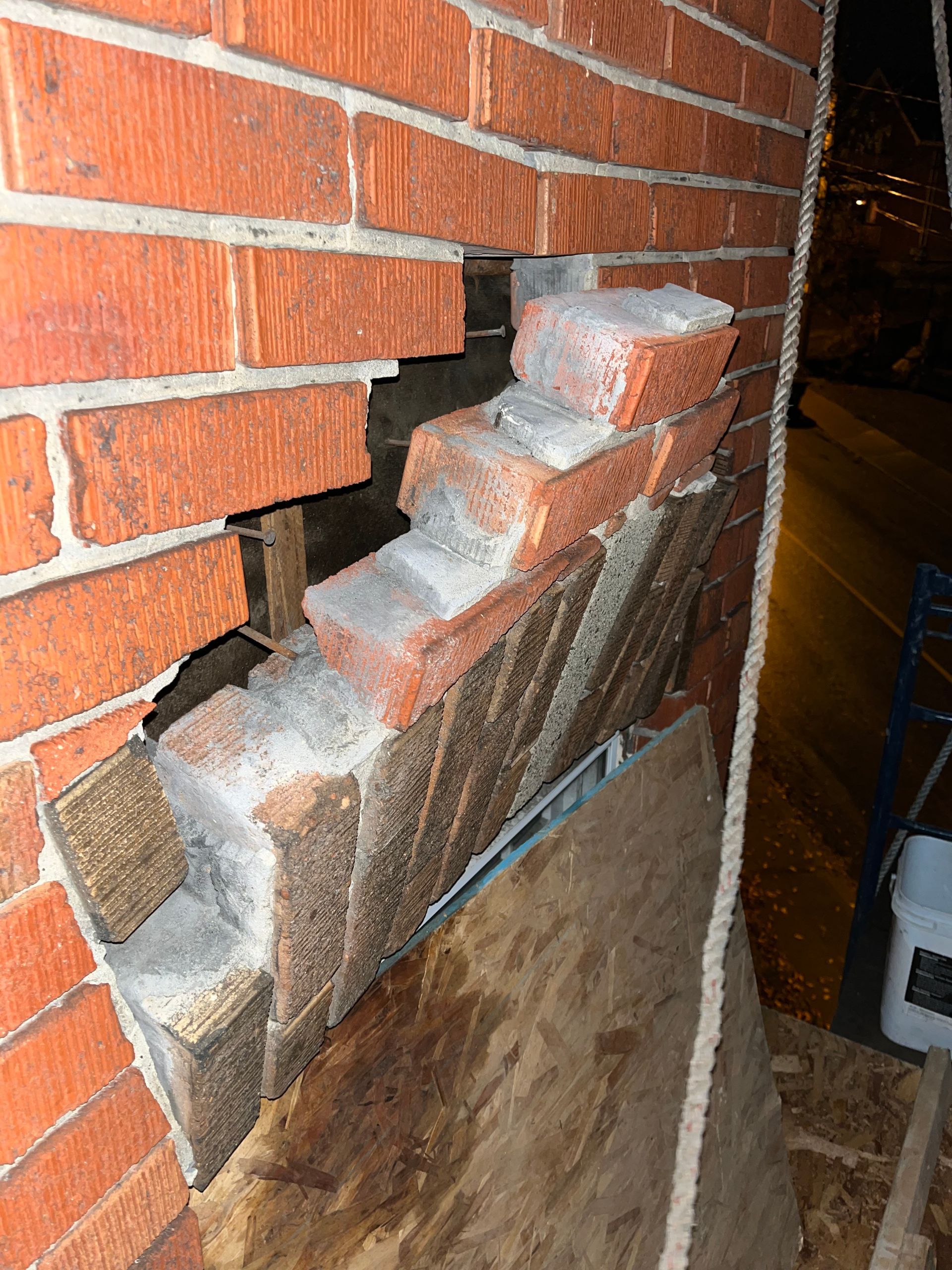 Un mur de briques percé d’un trou est en cours de réparation.