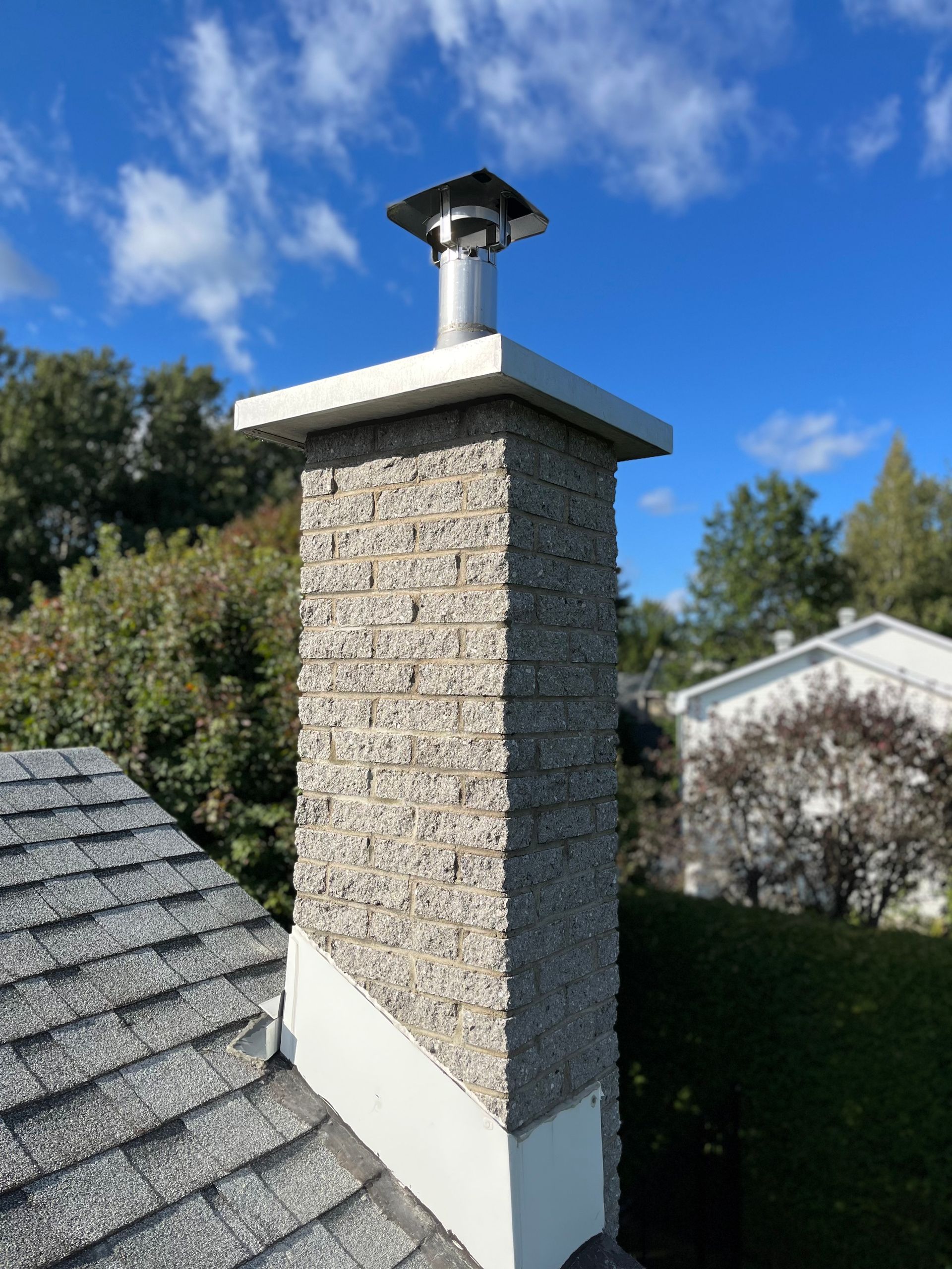 Une cheminée au sommet d'un toit avec un ciel bleu en arrière-plan
