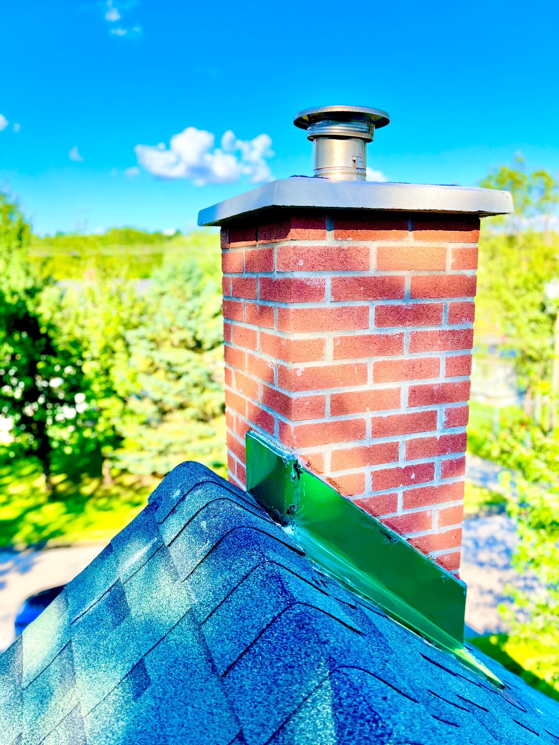Une cheminée en brique au sommet d'un toit bleu