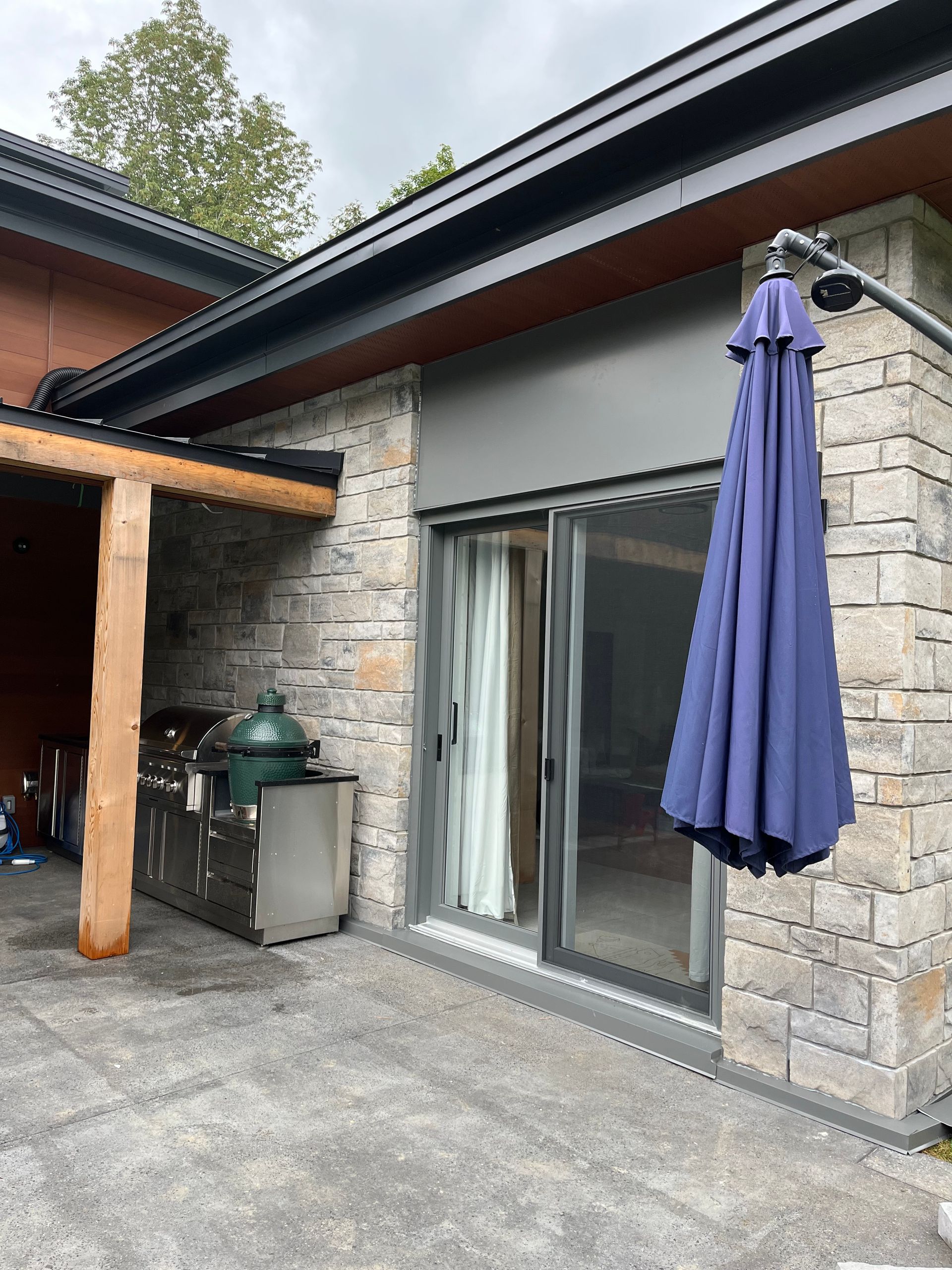 Un parapluie bleu est accroché sur le côté d’une maison.