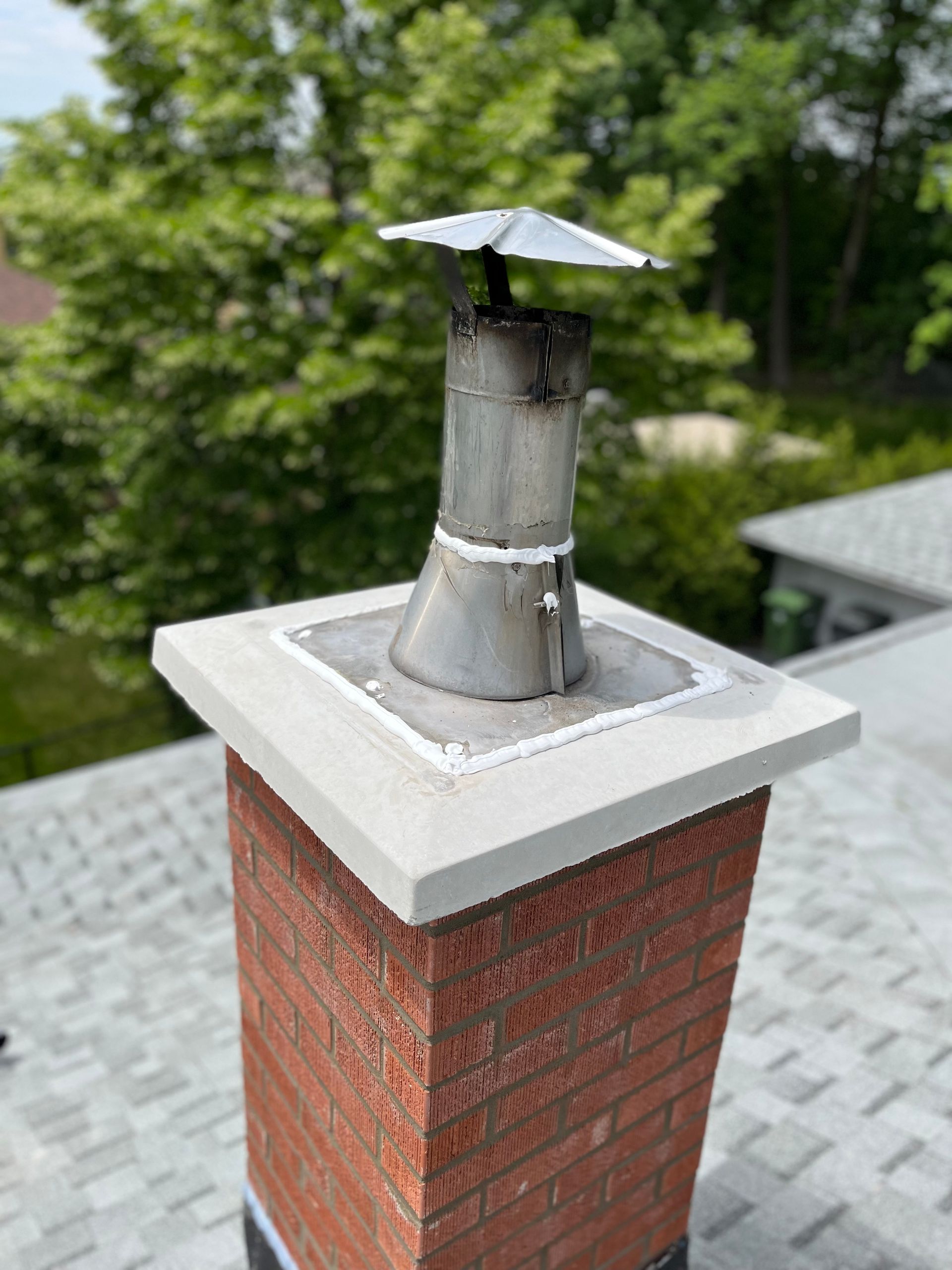 Une cheminée en brique se trouve au sommet d’un toit.