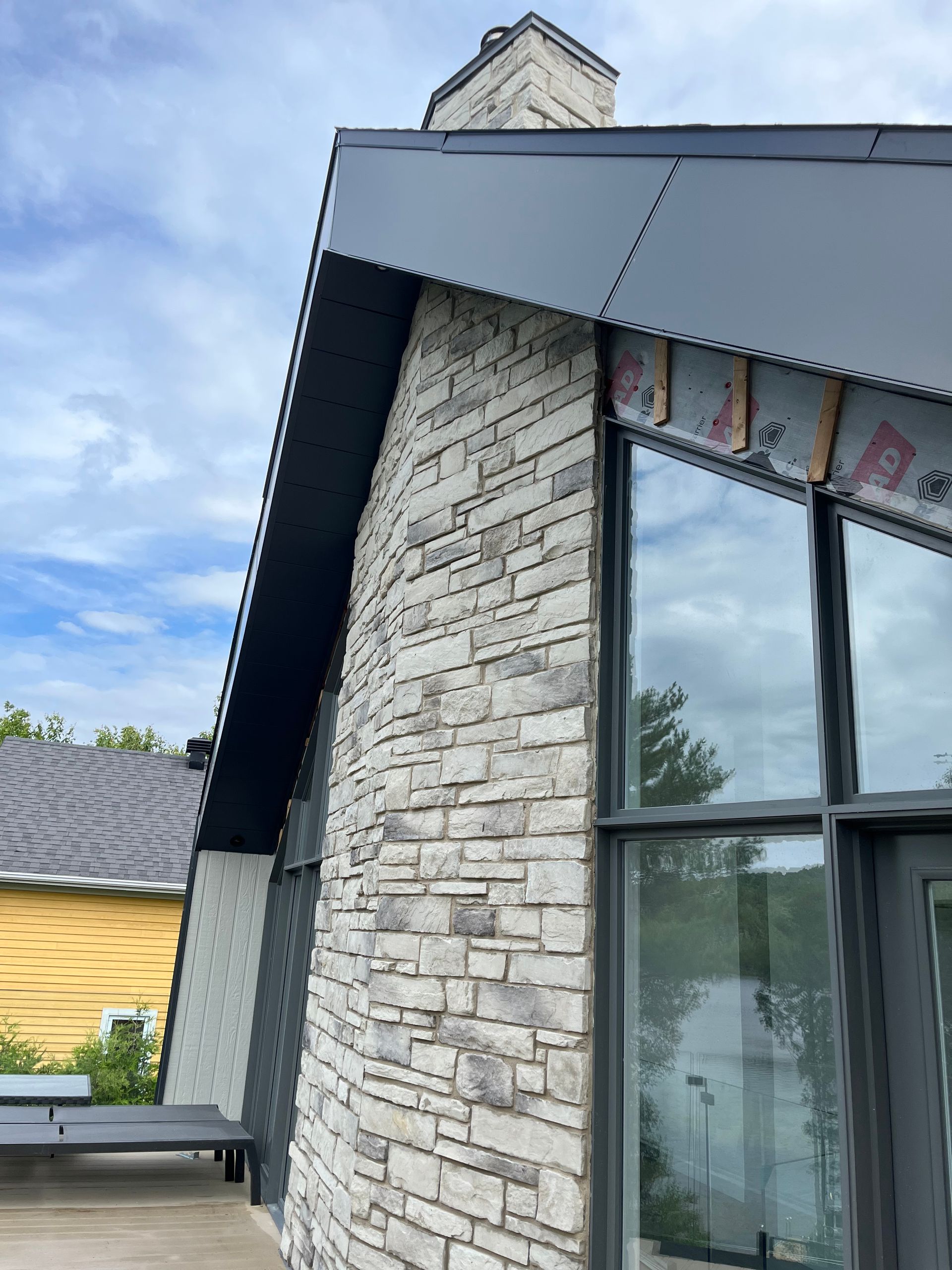 Un bâtiment en brique avec une grande fenêtre et une cheminée au sommet.