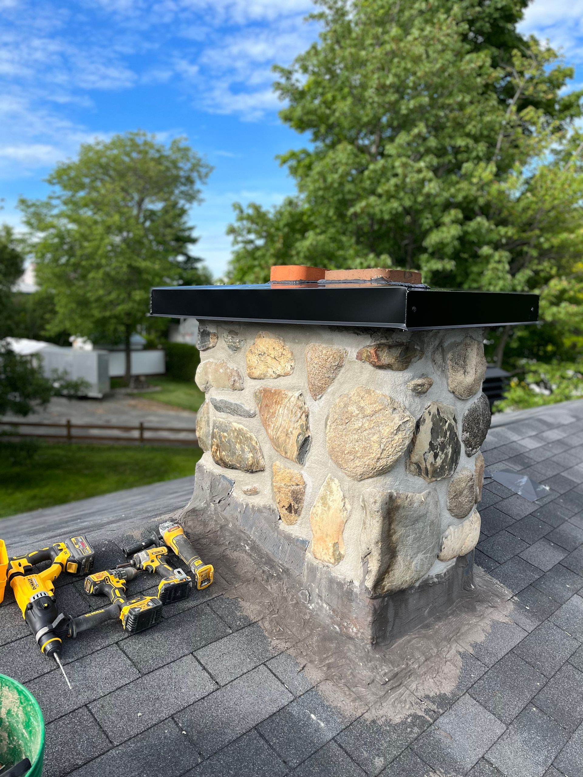 Une cheminée en pierre se trouve au sommet d'un toit.