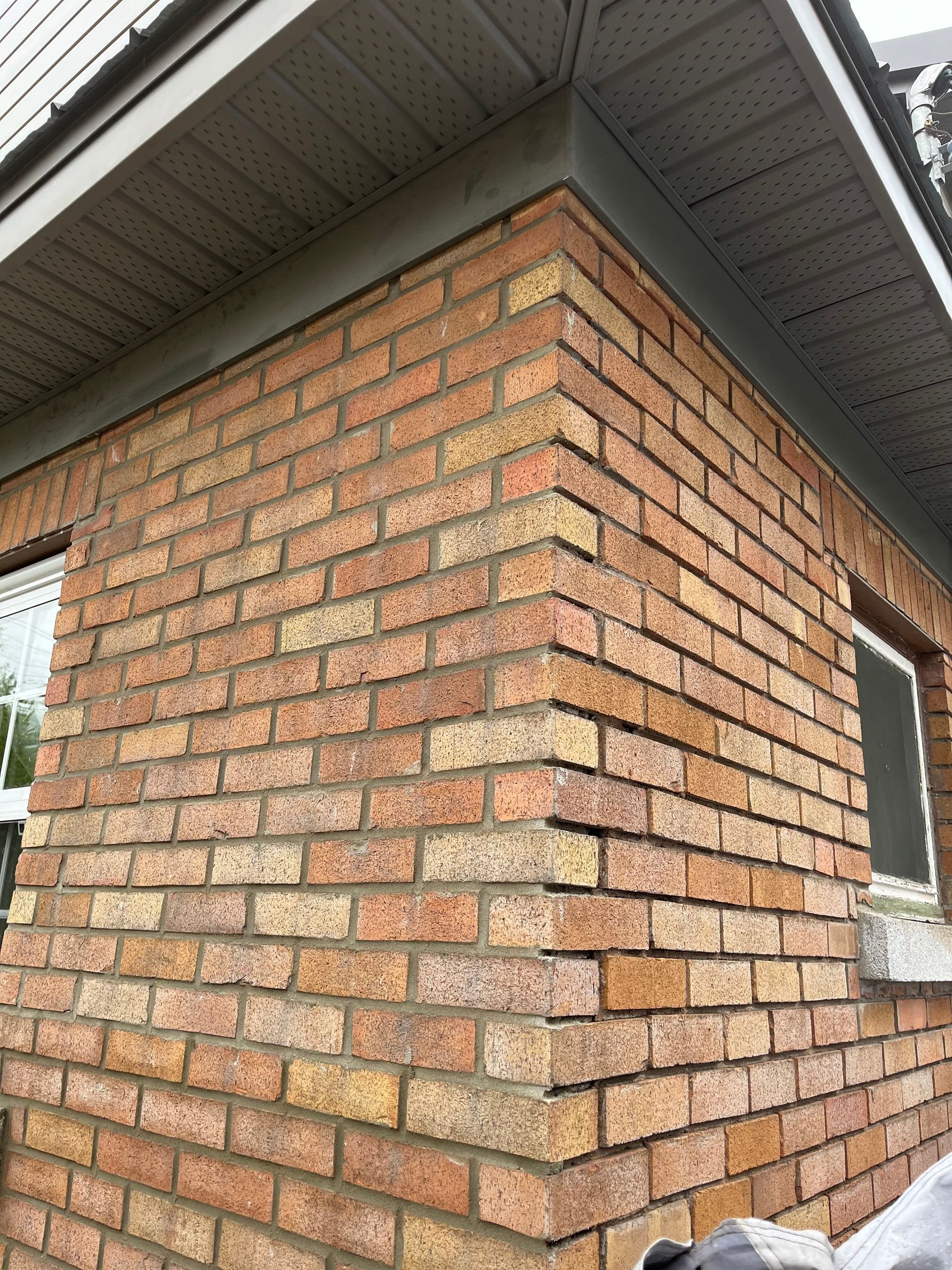 Un mur de briques avec une fenêtre sur le côté d'une maison.