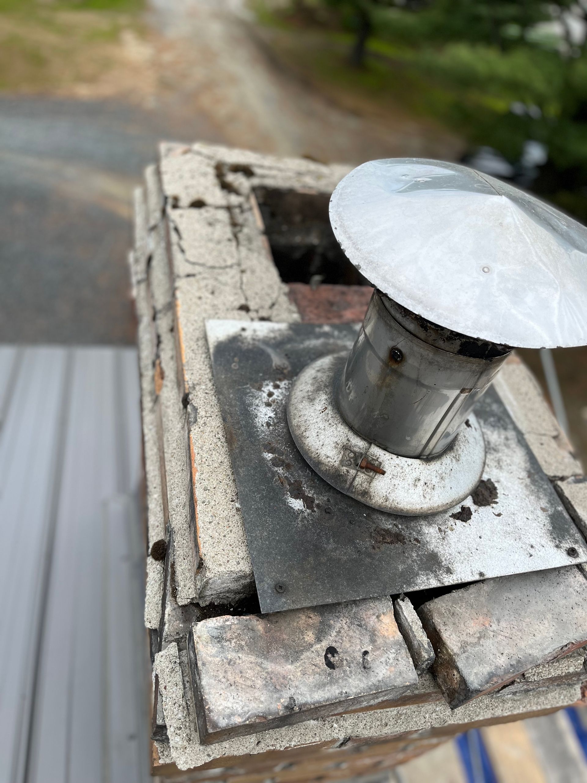 Un gros plan d'une cheminée surmontée d'un capuchon métallique.