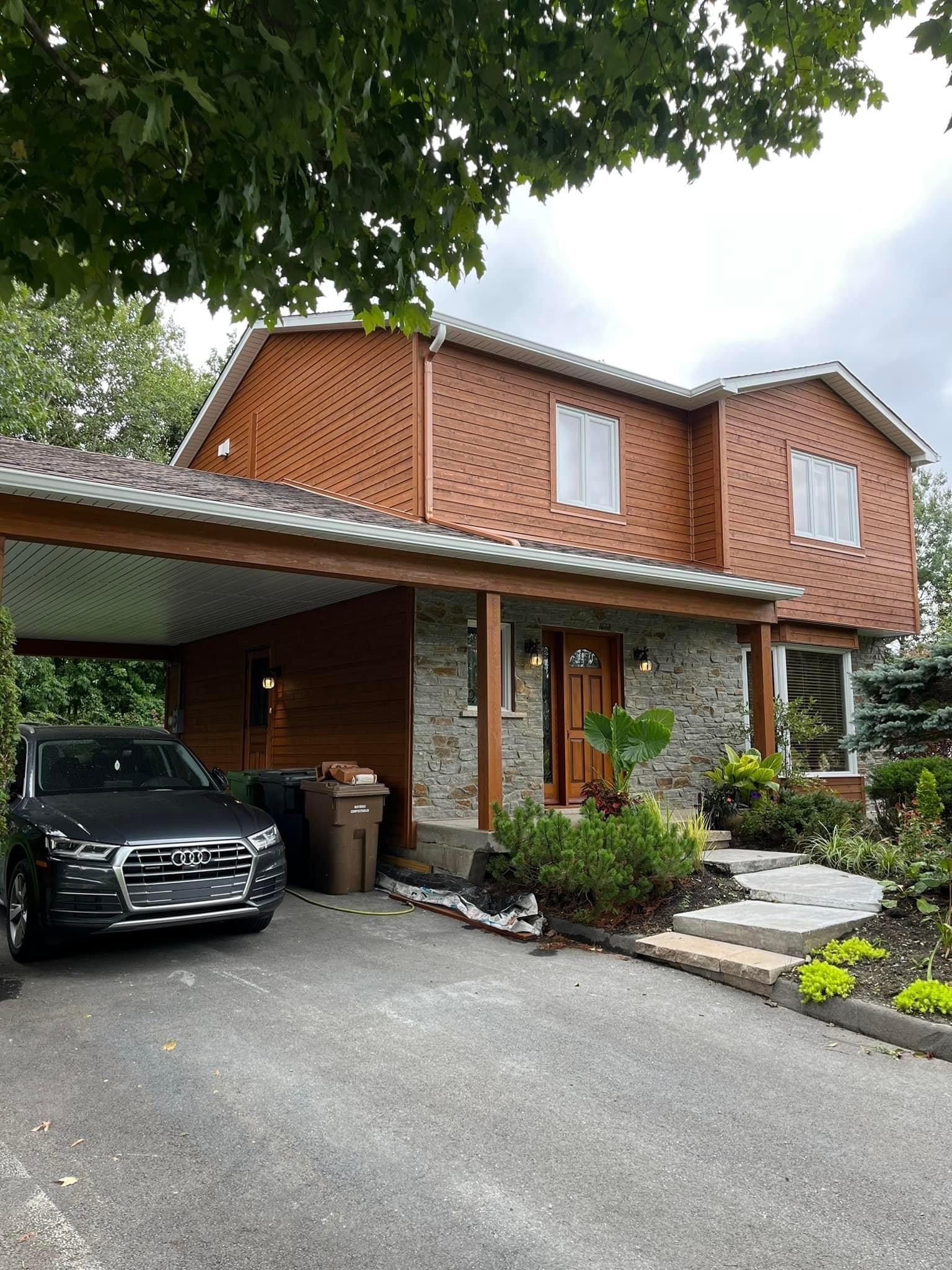 Une voiture est garée devant une grande maison.
