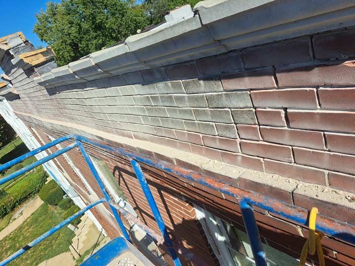 Brick wall of a building with a blue lift platform; the bricks are a mix of red and gray.