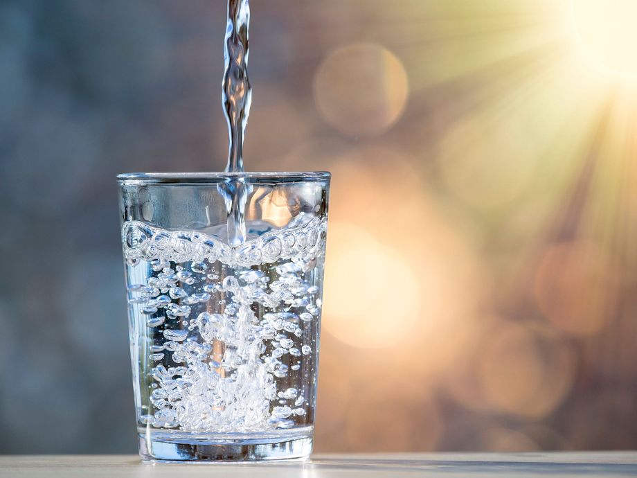 L'acqua viene versata in un bicchiere su un tavolo.