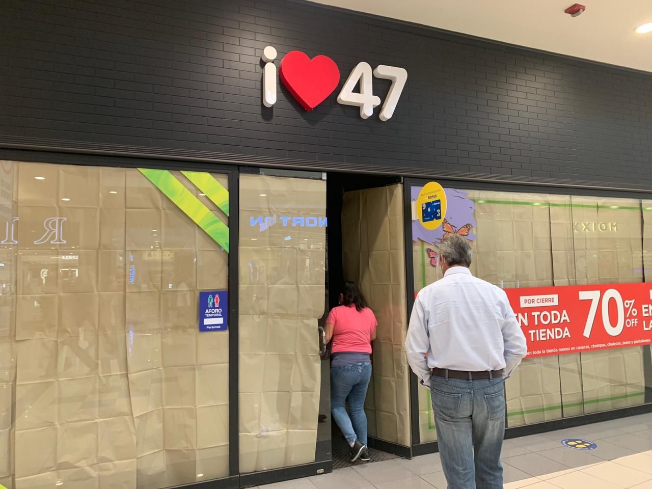 Un hombre parado frente a una tienda que dice 