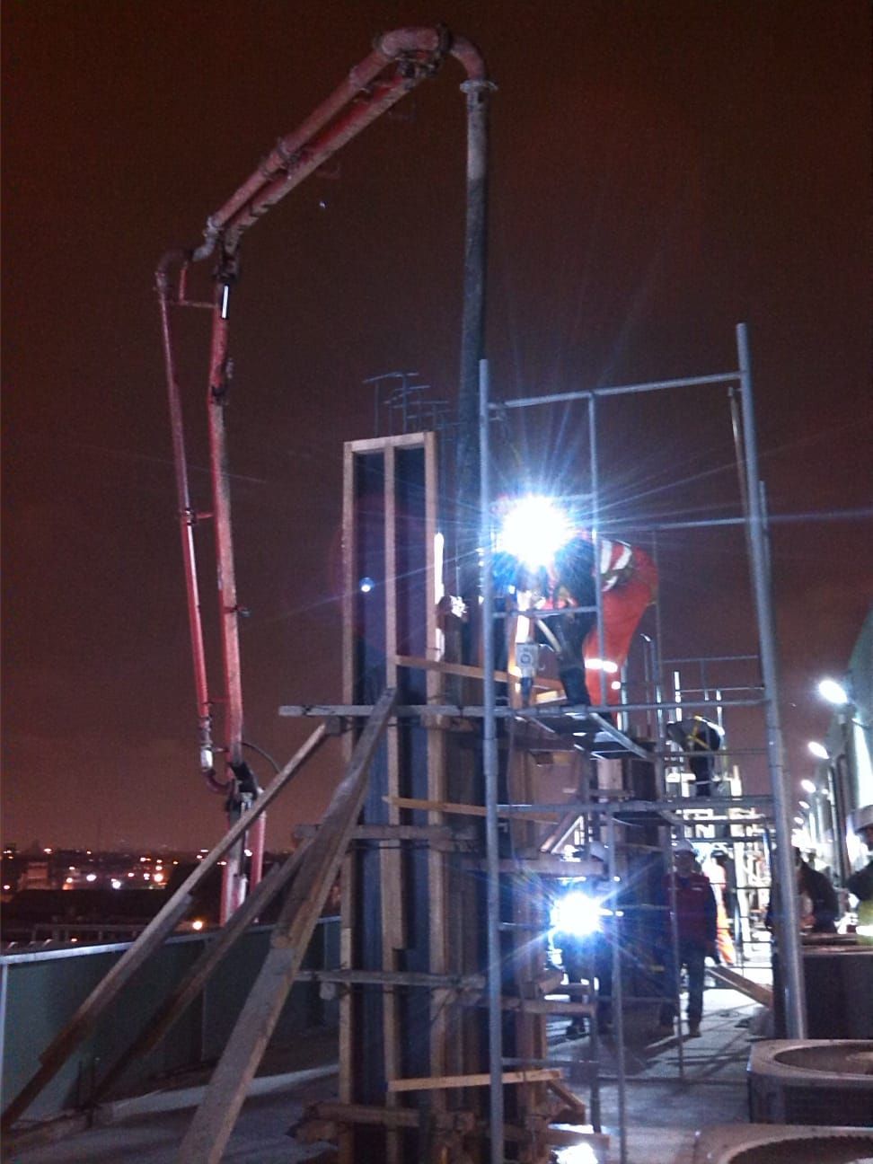 Se utiliza una grúa para verter hormigón por la noche.