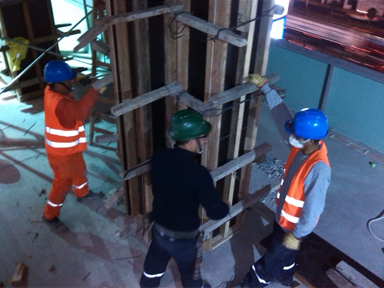 Un grupo de trabajadores de la construcción que llevan cascos y chalecos de seguridad.