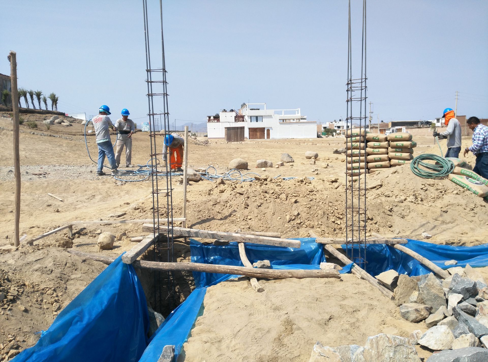 Un sitio de construcción con una lona azul en el suelo.