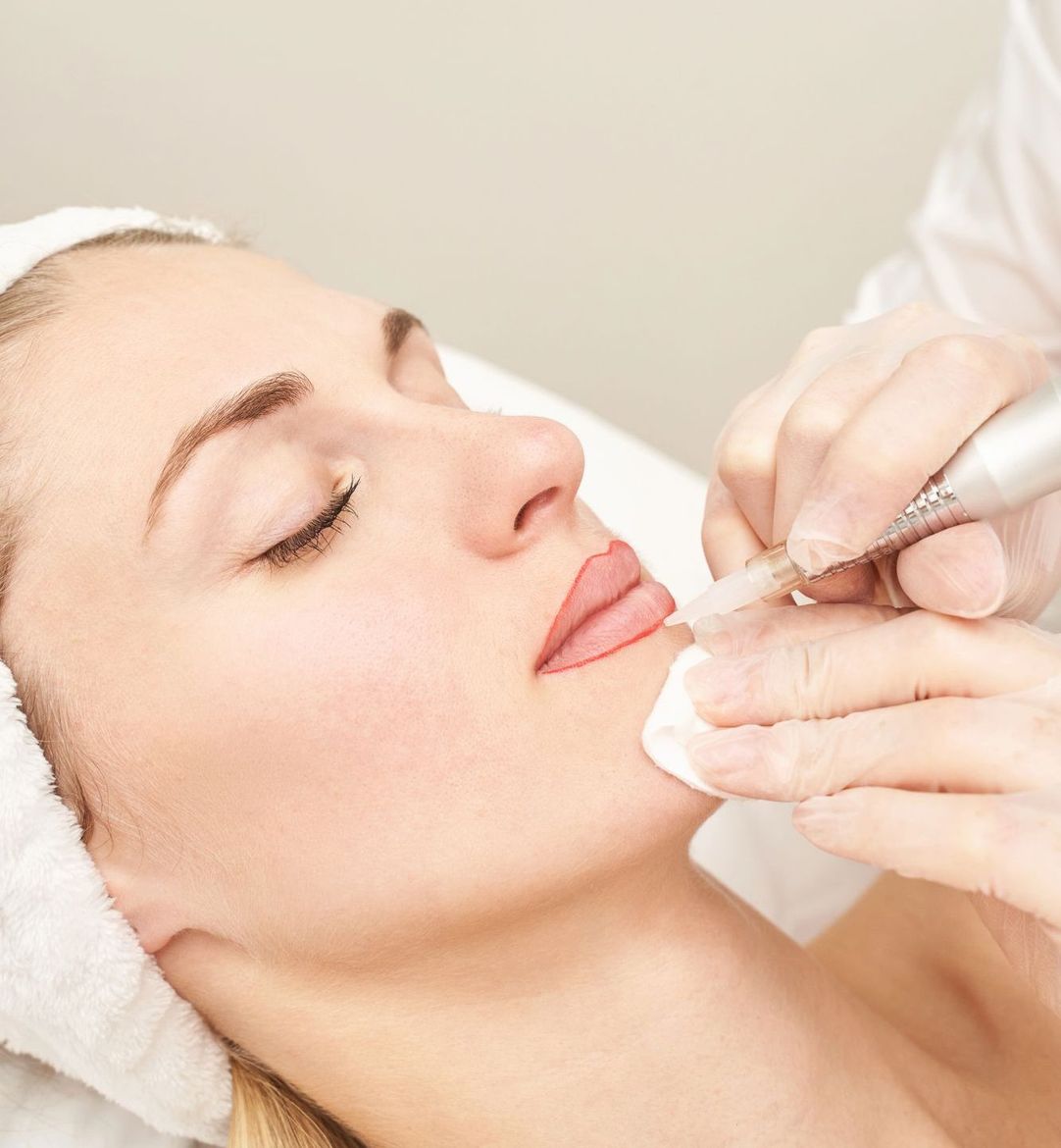 Una mujer con una toalla en la cabeza está recibiendo un tratamiento facial.