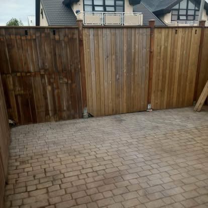 Trégirðingarplötur á múrsteinsverönd. Platurnar eru mismunandi að lit og ástandi.