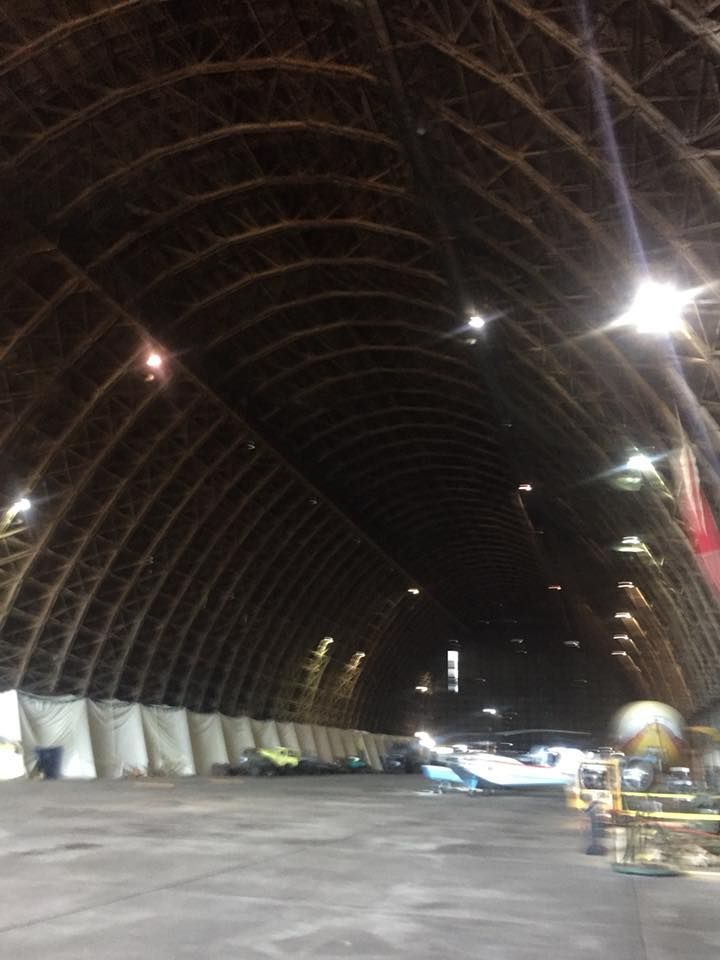A large warehouse with a lot of planes inside of it.