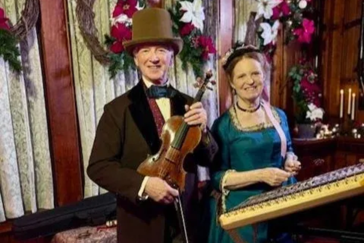 Tea setting on a table, with cups, teapot, and napkins. A window and chairs are in the background.