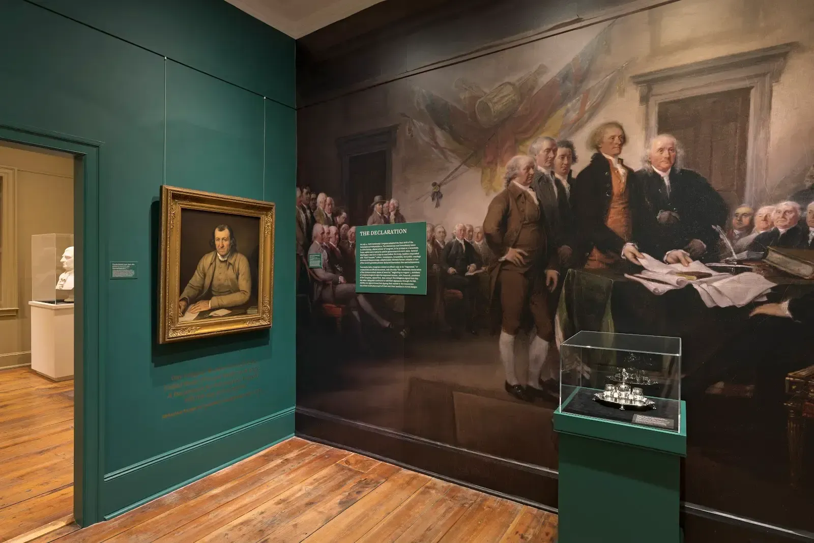 Green doorway to exhibit room with artwork and text 