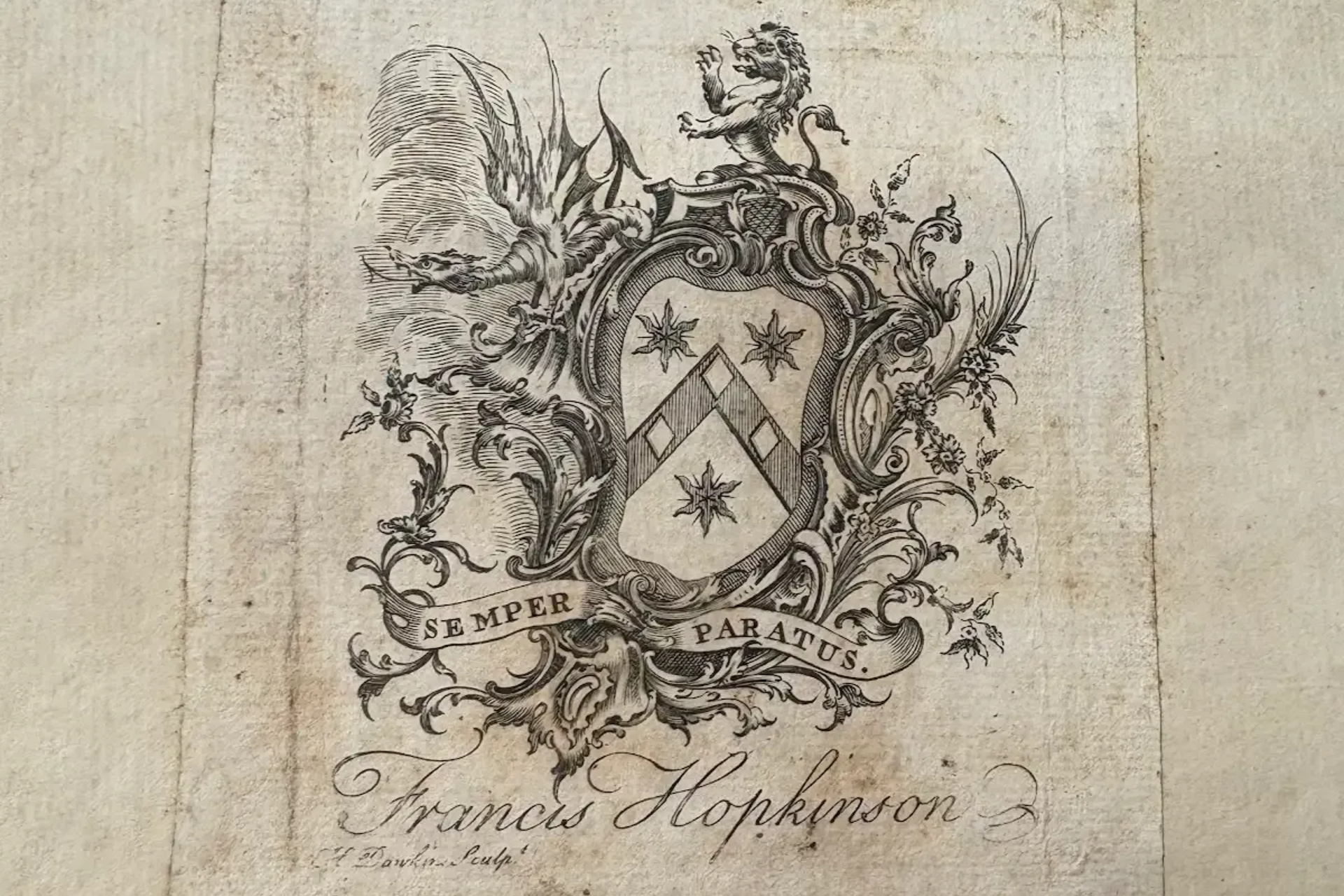 Tea setting on a table, with cups, teapot, and napkins. A window and chairs are in the background.