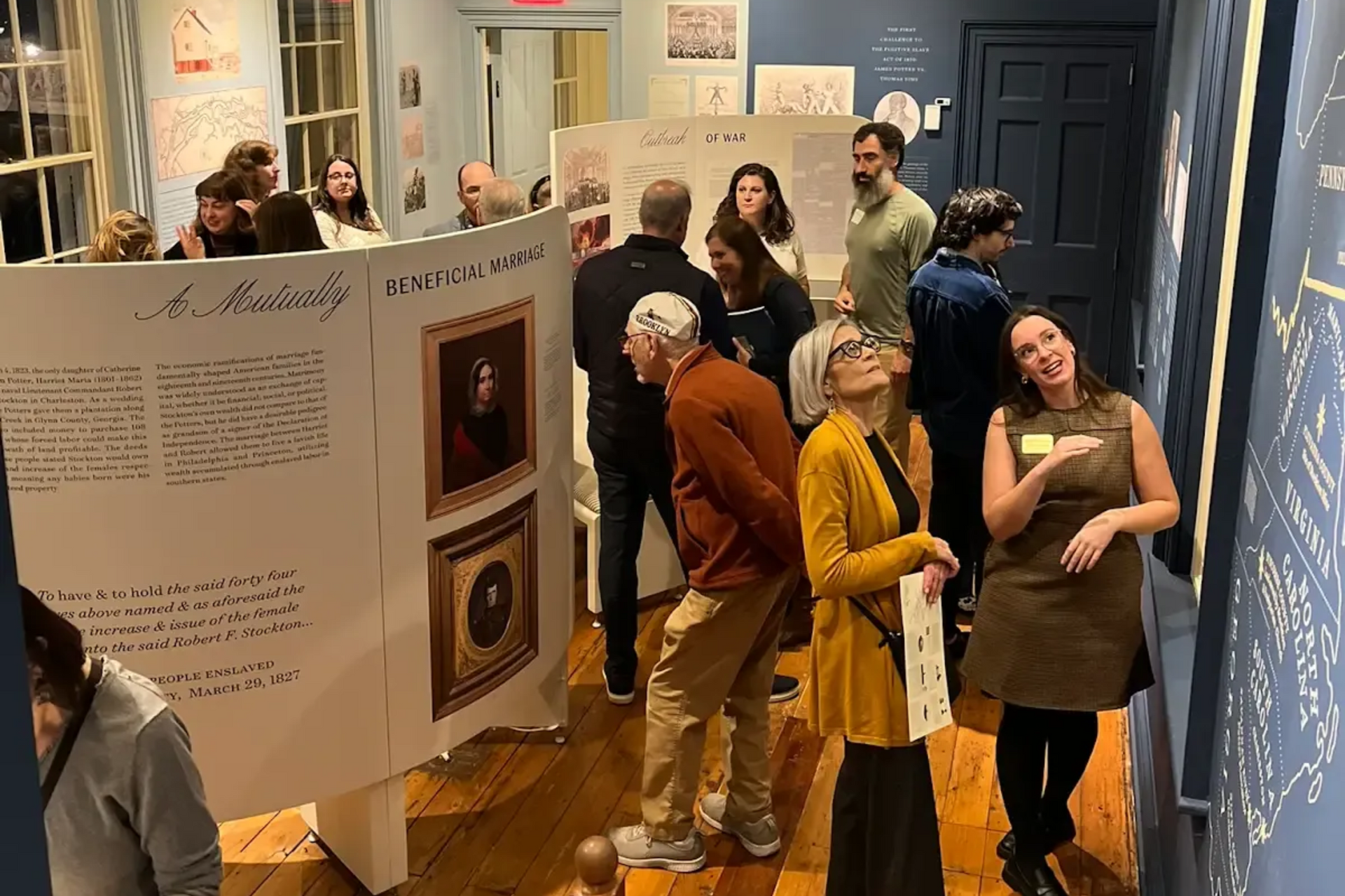 Tea setting on a table, with cups, teapot, and napkins. A window and chairs are in the background.
