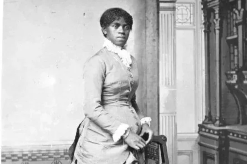 Tea setting on a table, with cups, teapot, and napkins. A window and chairs are in the background.