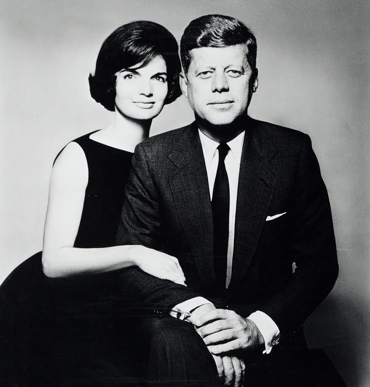 John F. Kennedy and Jacqueline Kennedy in formal attire, posing together. Black and white photo.